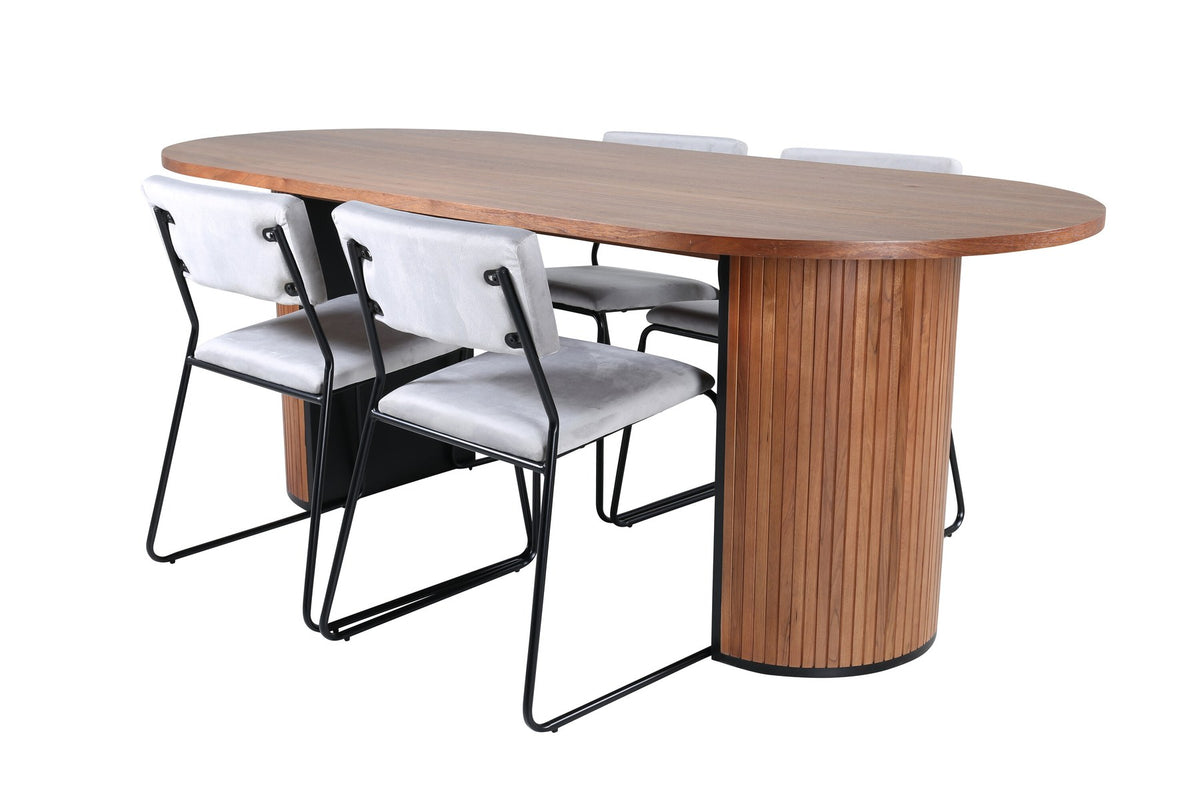 Zwei graue Esszimmerstühle mit schmalen Metallbeinen und samtigem Sitz neben ovalem Esstisch aus Nussbaum-MDF mit Furnier, 200x90cm.