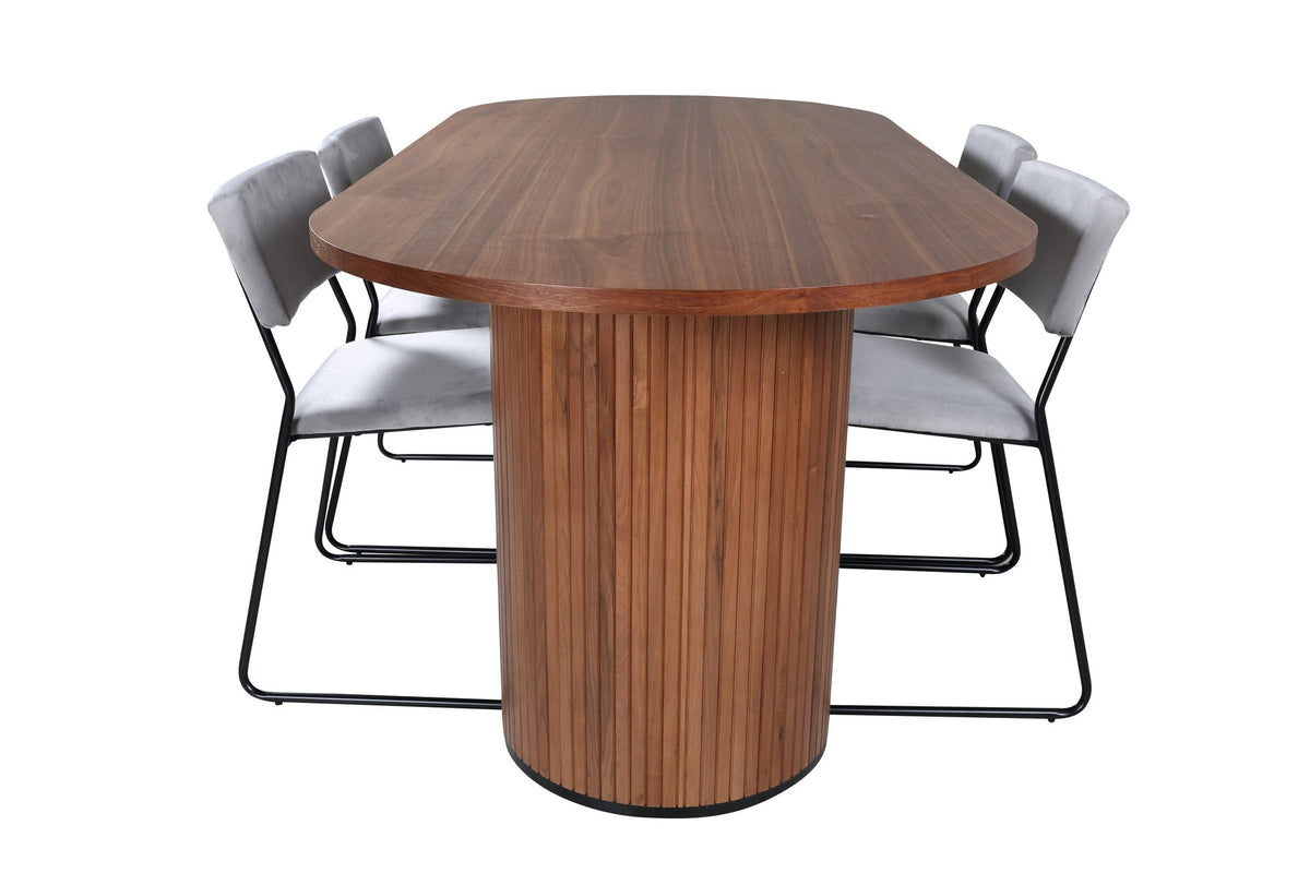 Zwei graue Esszimmerstühle mit schmalen Metallbeinen und samtigem Sitz neben ovalem Esstisch aus Nussbaum-MDF mit Furnier, 200x90cm.