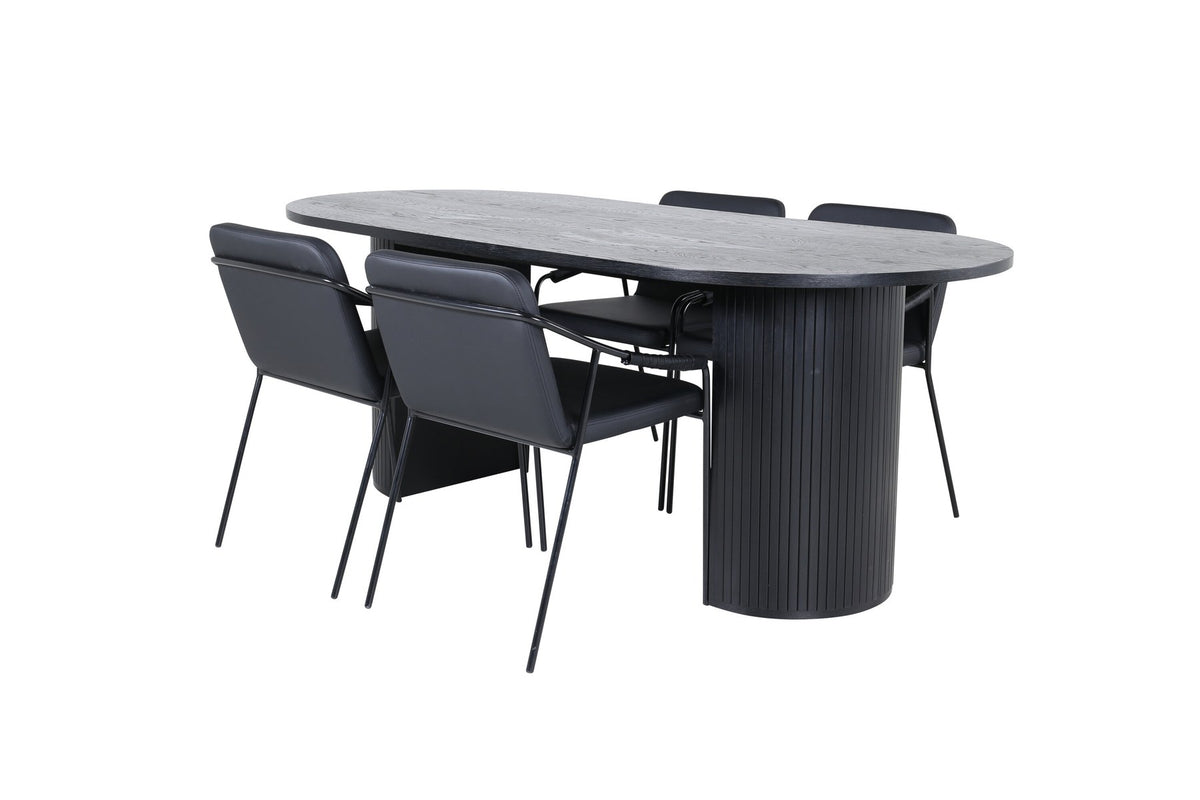 Zwei schwarze Esszimmerstühle mit Beinen aus Eisen und Sitzfläche aus Polyurethan-Membran neben ovalem MDF-Esstisch in Schwarz.
