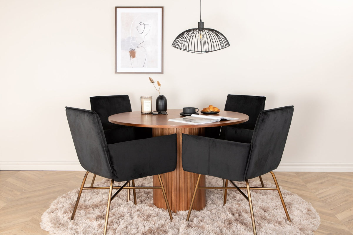 Rundes Esszimmerset mit Nussbaum-Tischplatte Ø110cm aus MDF und vier schwarzen Stühlen mit Samtsitz und Beinen aus Eisen.