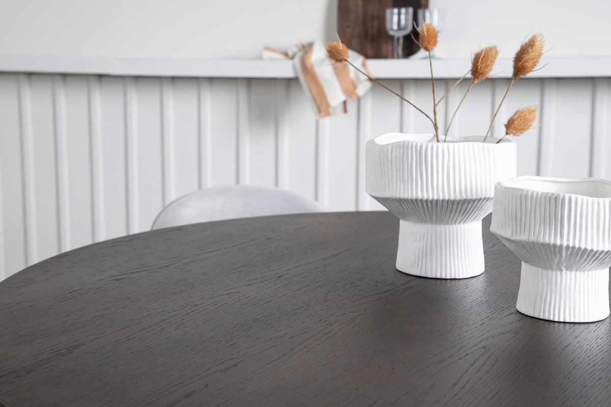 Rundes Esszimmerset mit Steinlook-Tisch aus MDF und Mocca-Furnier, schwarzem Metallgestell und vier Limhamn-Stühlen mit beigem Samtbezug.