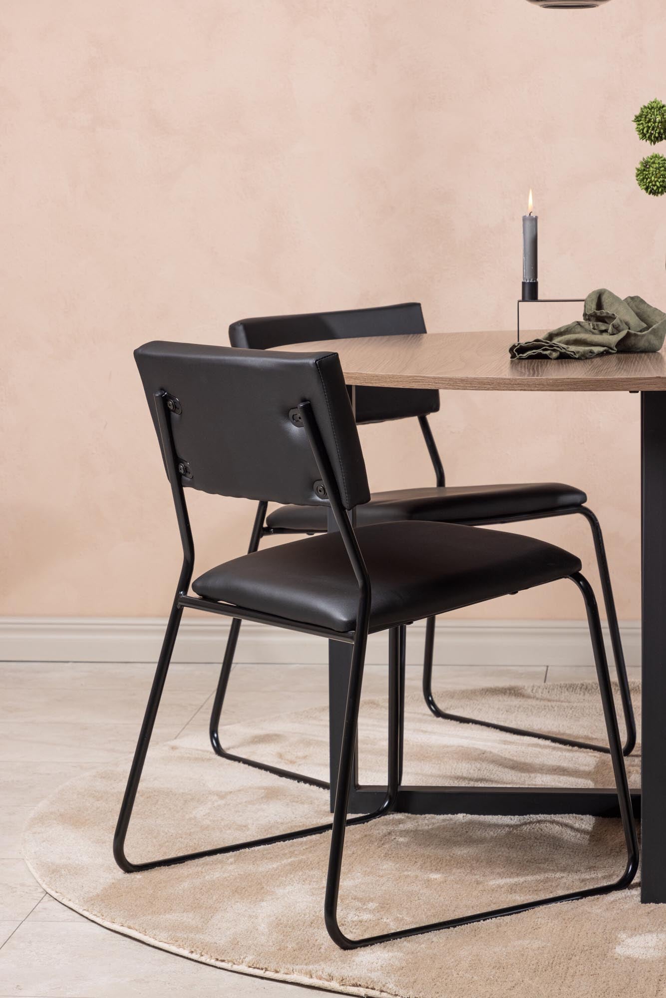 Stilvolles Durango Esszimmerset: Runder Walnusstisch und bequeme Kenth-Stühle, ideal für moderne Wohnräume und gesellige Anlässe.