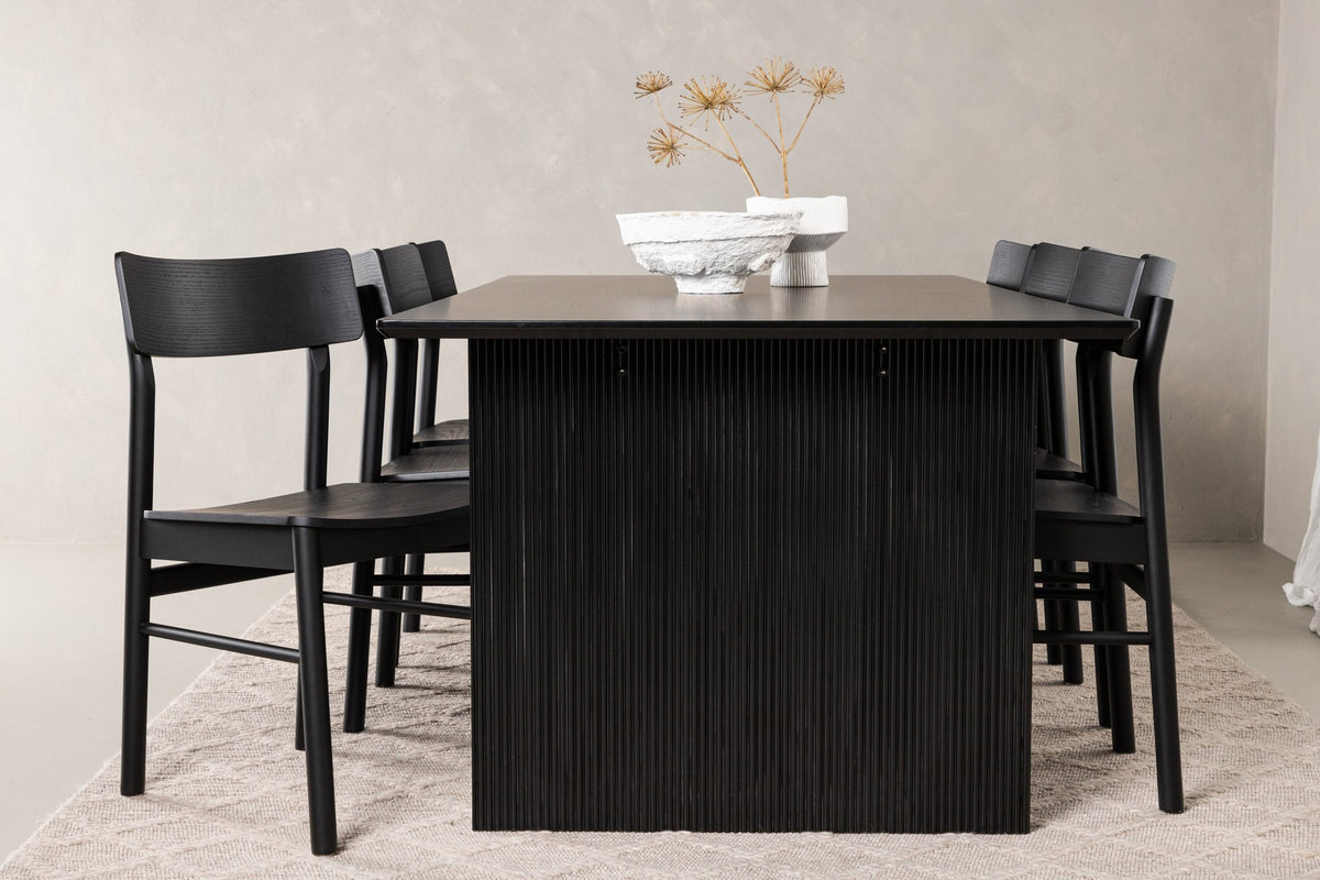 Esszimmerset aus rechteckigem MDF-Tisch in Rauchschwarz mit sechs Limhamn-Stühlen, beiger Samtbezug, muschelförmige Rückenlehne, schwarze Metallbeine.