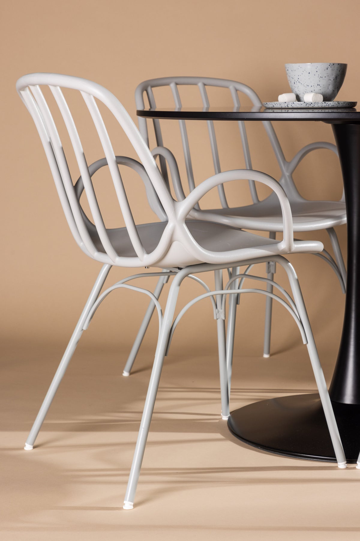 Schwarzes Esszimmerset Glade mit rundem MDF-Tisch und vier Dyrön-Stühlen aus Kunststoff und Stahl, skandinavisches Design.