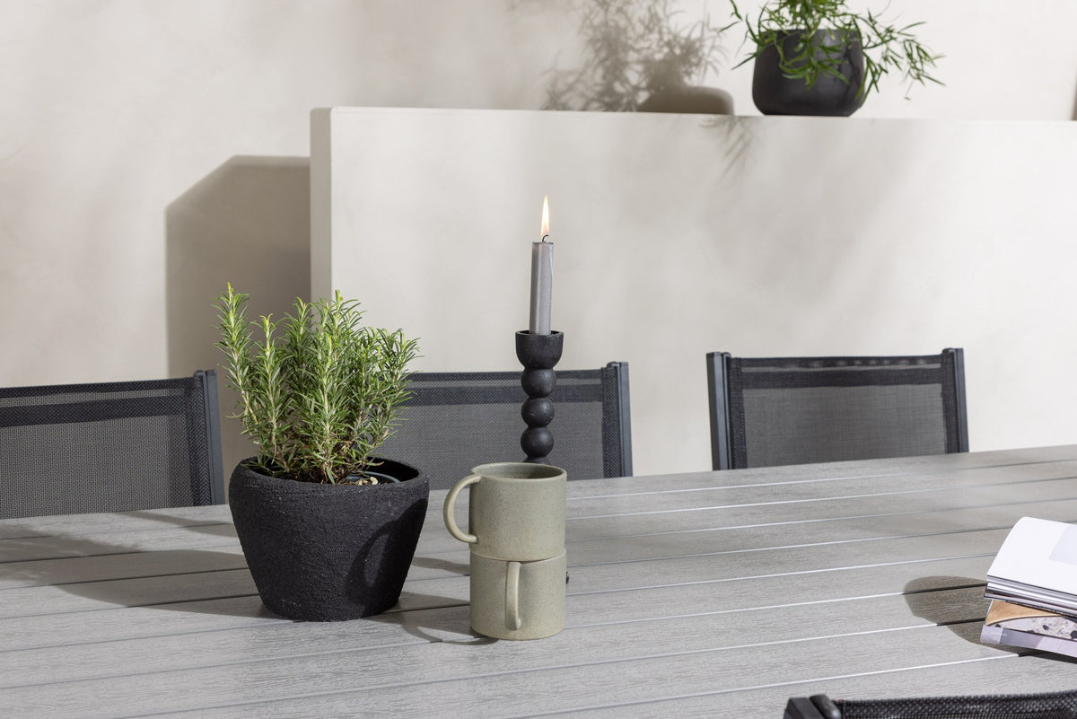Rechteckiger Gartentisch Garcia mit Aluminiumgestell und Aintwood-Platte, umgeben von sechs stapelbaren Copacabana-Stühlen mit Textilene-Sitzfläche.