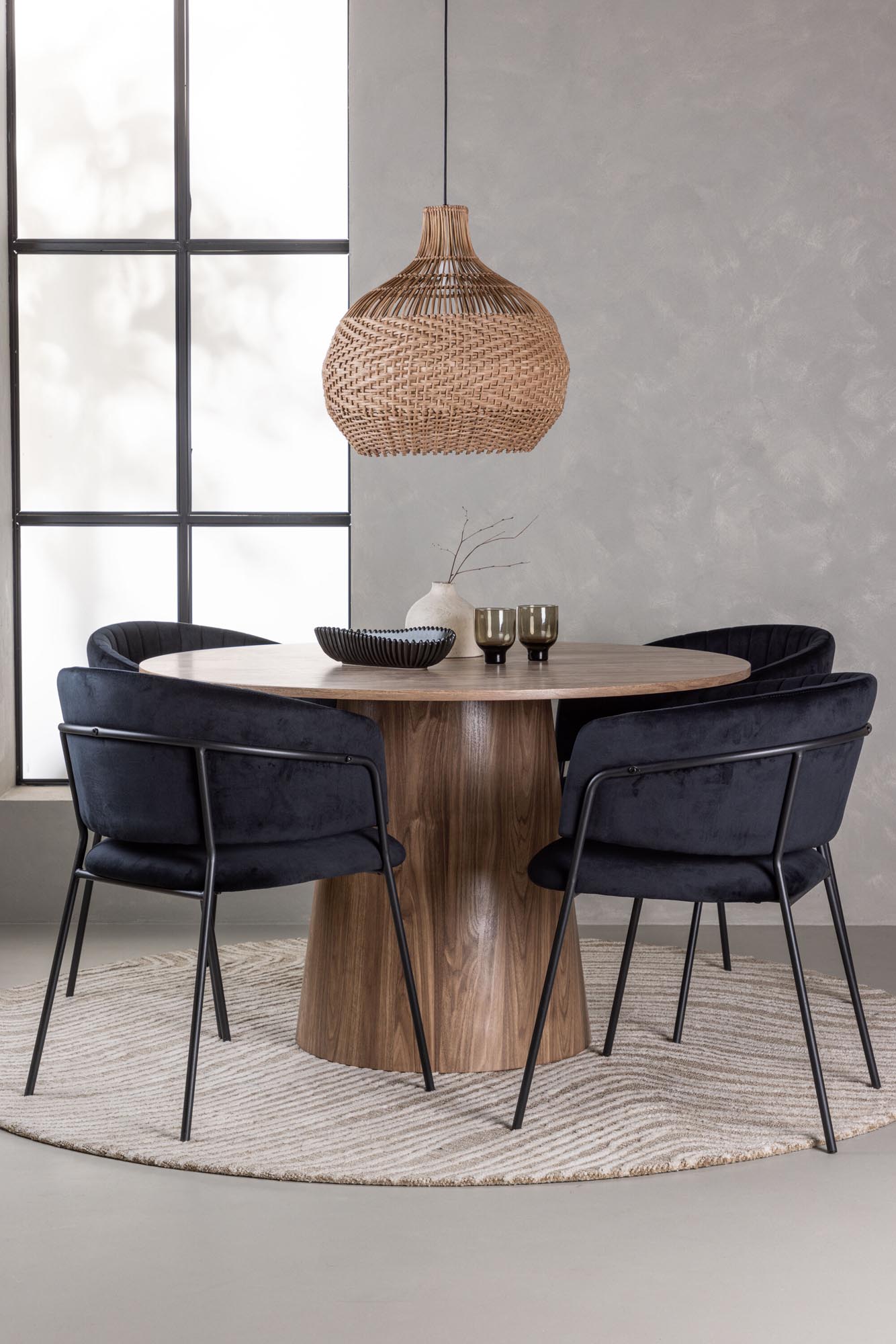 Stilvolles Esszimmerset mit rundem Tisch und bequemen Samtstühlen für gesellige Runden.