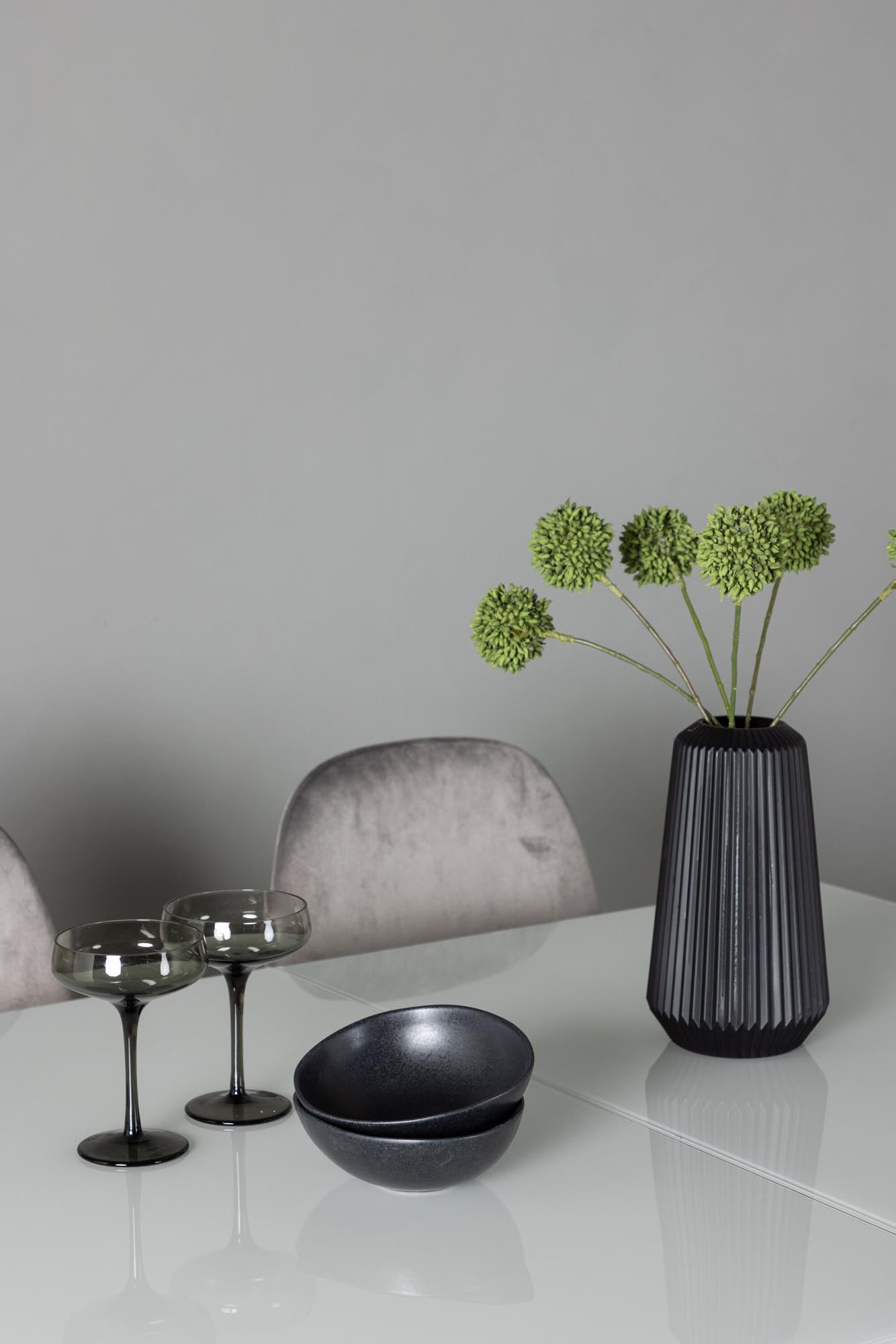 Entdecken Sie das Pluto Esszimmerset von Venture Home: Ausziehbarer Tisch mit eleganter Glasoberfläche und bequemen Samtstühlen für stilvolle Esszimmer.