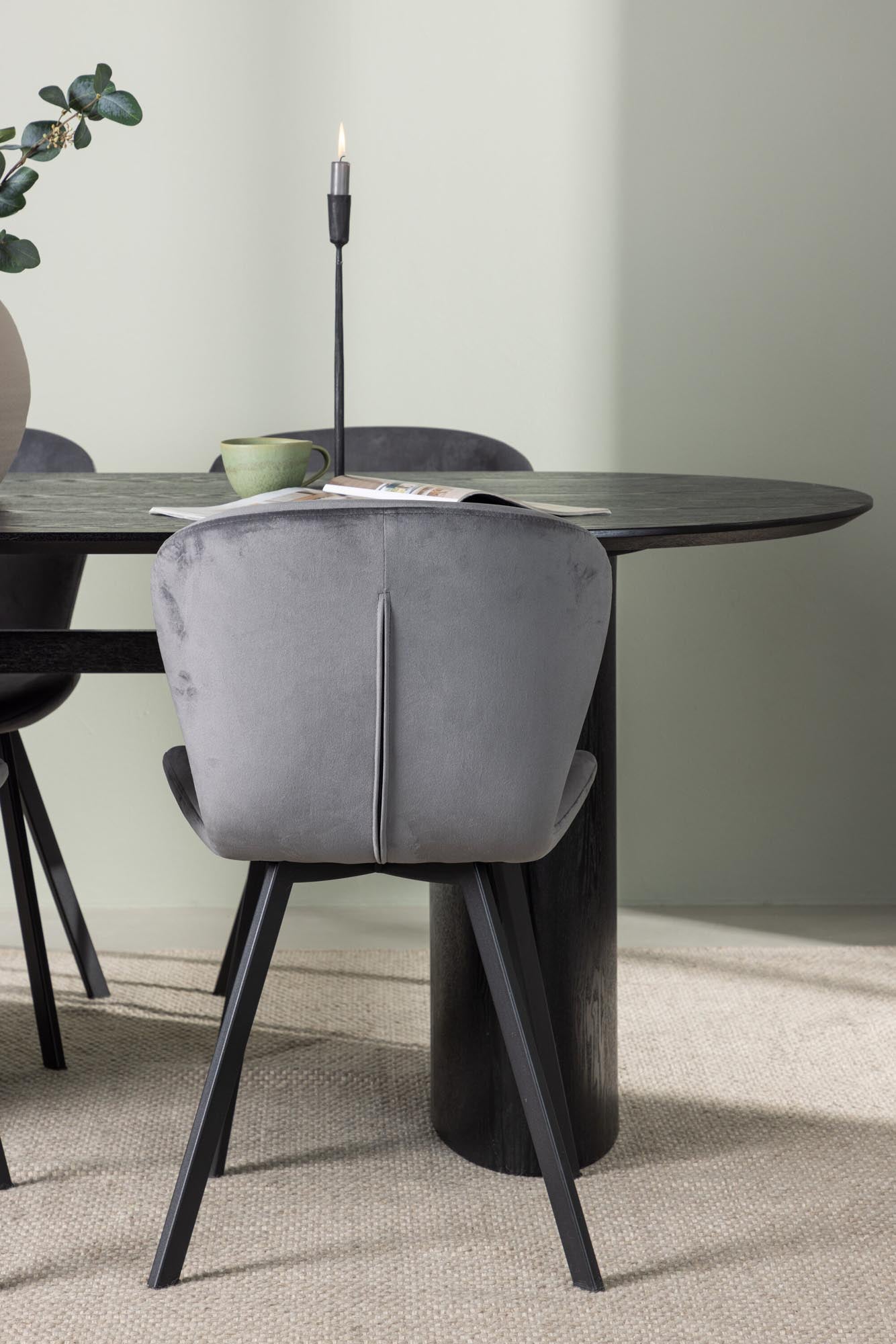 Stilvolles Isolde Esszimmerset: Ovaler Tisch in Schwarz, komfortable Lilja-Stühle, perfekte Kombination für gesellige Abende und modernes Wohnen.