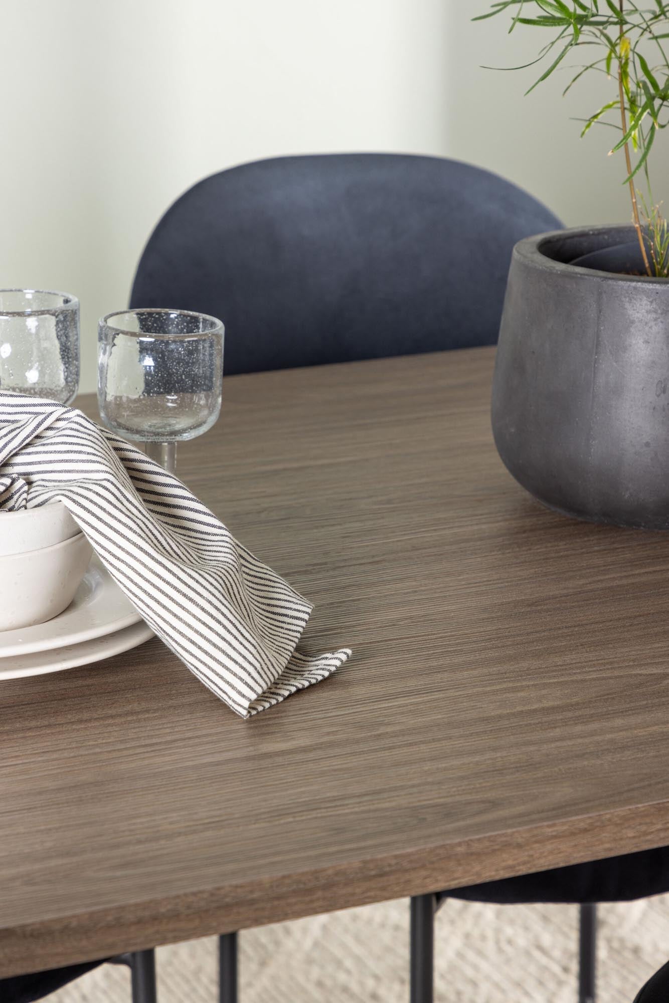 Elegantes Andy Esszimmerset mit 180 cm Tisch und 4 stilvollen Stella Stühlen aus schwarzem Samt. Ideal für gemütliche Mahlzeiten und besondere Anlässe.