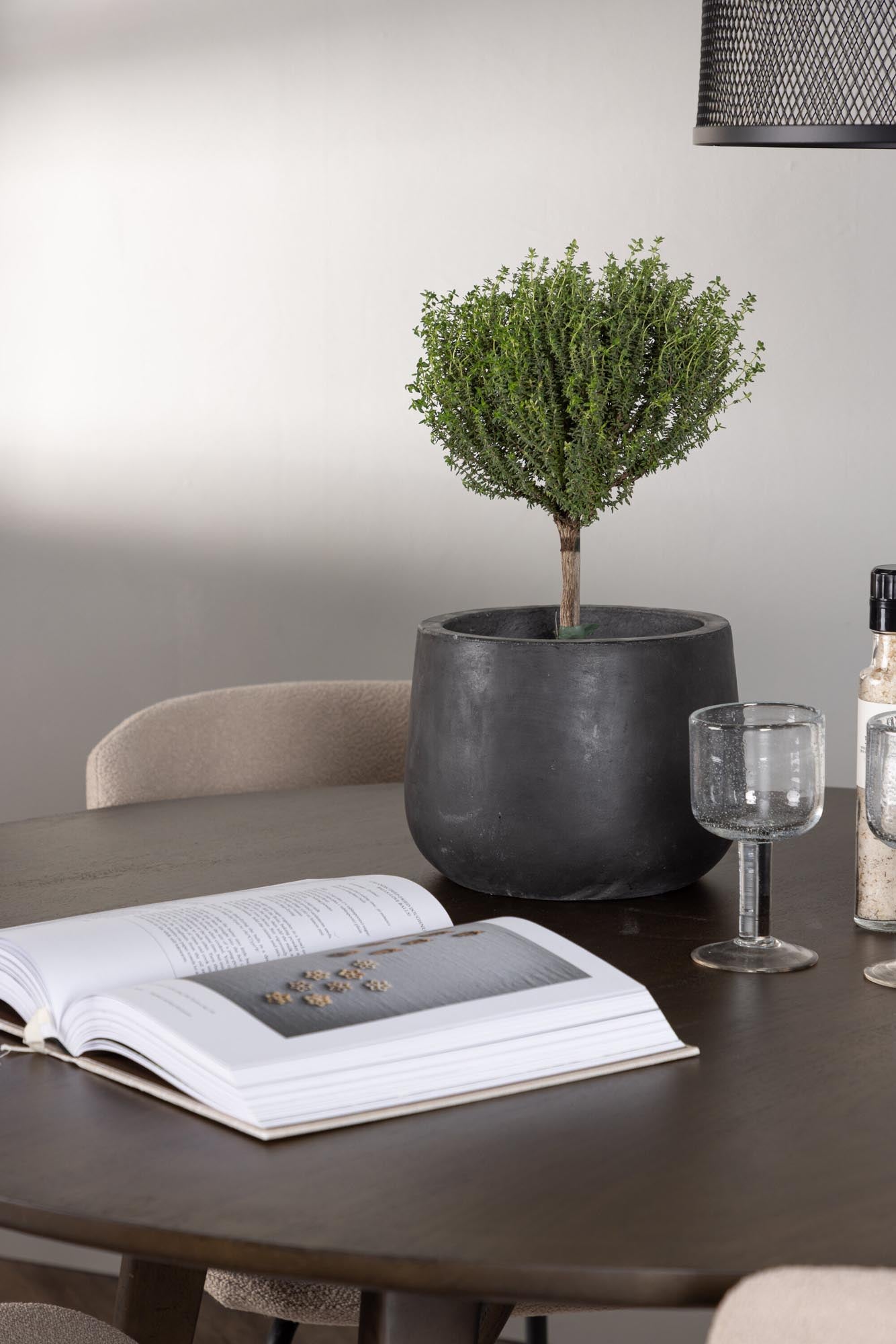 Stilvolles Esszimmerset mit runden Walnusstisch und gemütlichen Bouclé-Stühlen. Perfekt für gesellige Abende mit bis zu 4 Personen.