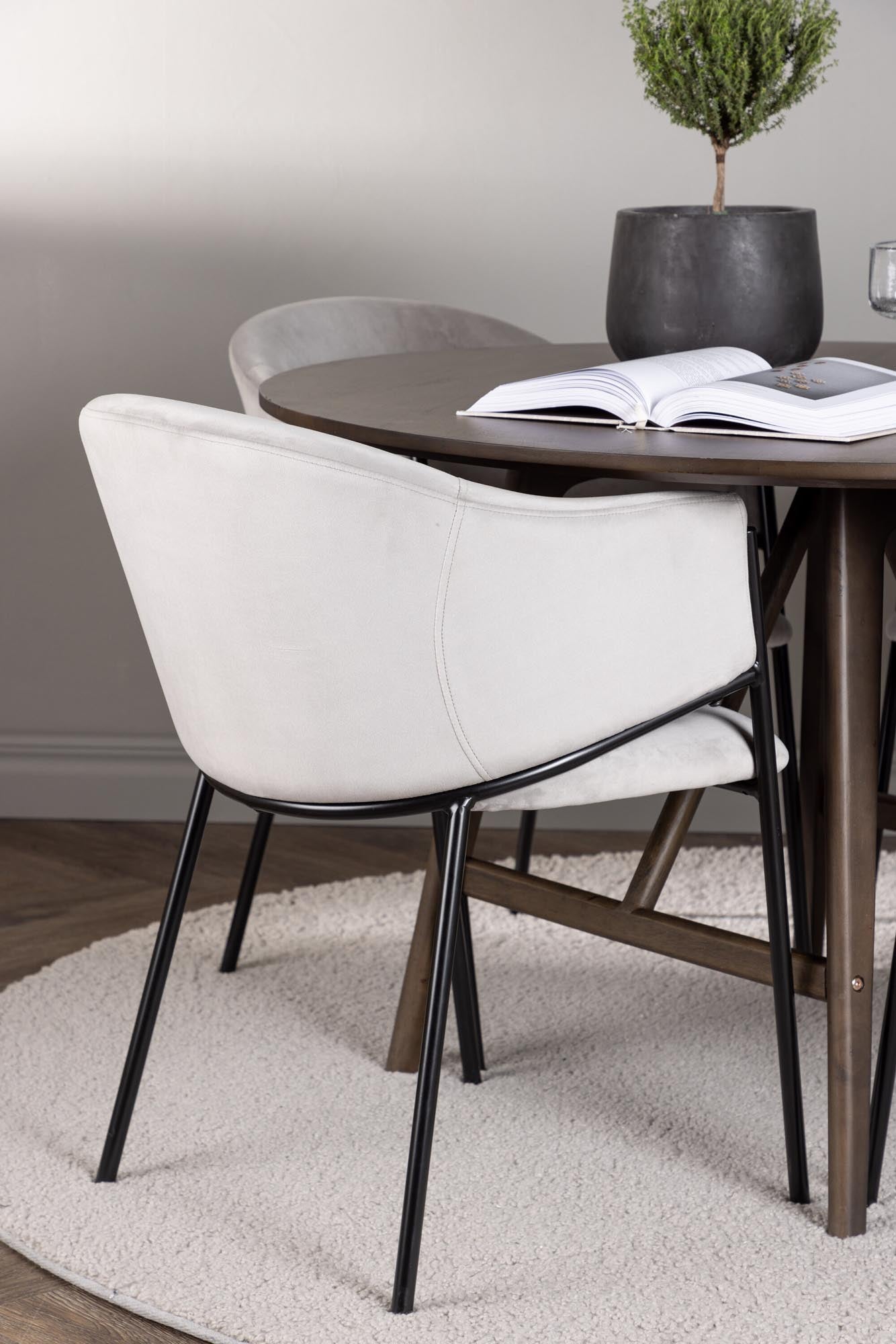 Stilvolles Esszimmerset Kaseindon: Runder Tisch (⌀100cm) aus Gummibaumholz und 4 komfortable Evelina-Stühle aus Samt und Stahl. Ideal für gesellige Momente.