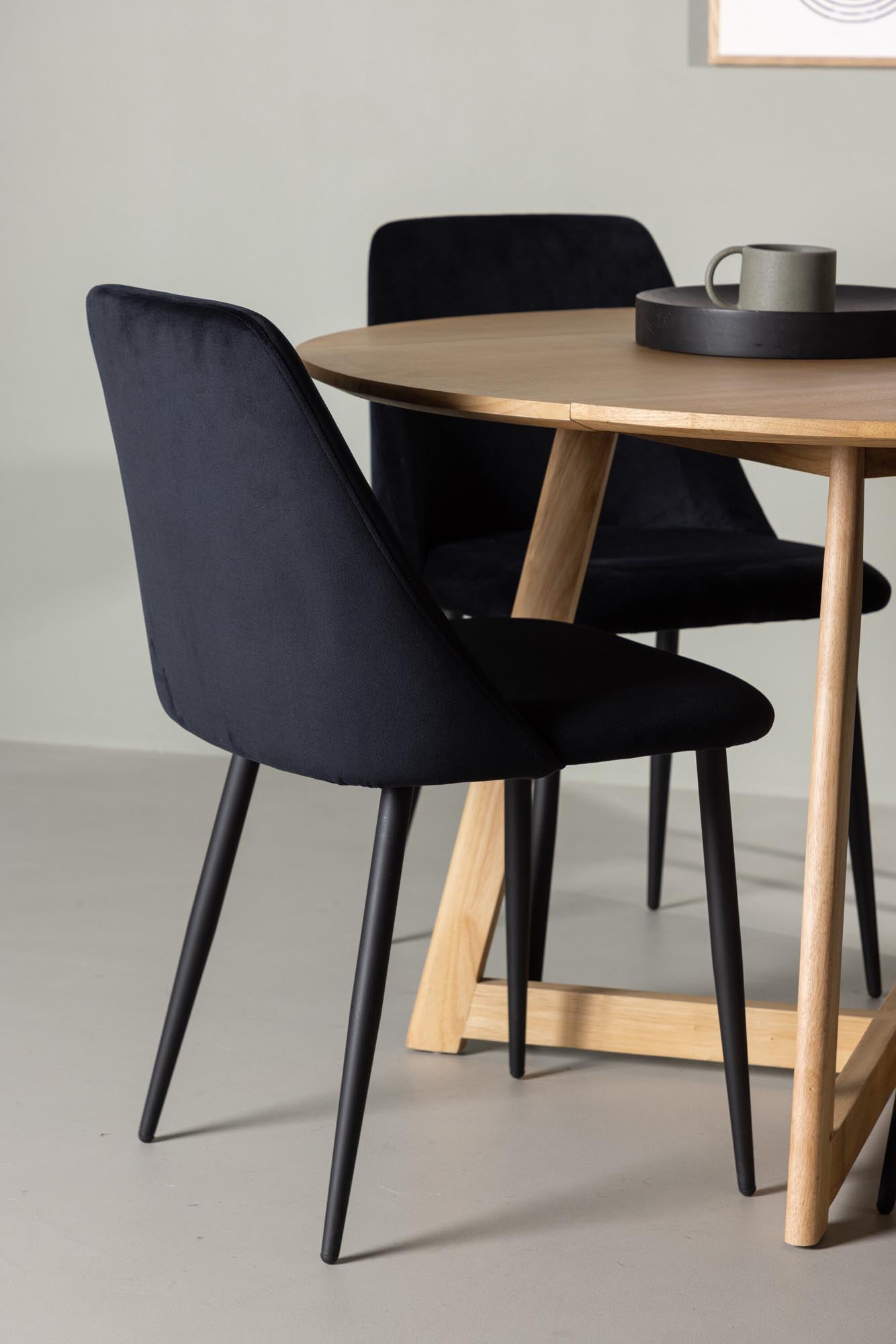 Entdecken Sie das Yadikon Esszimmerset von Venture Home: Runder Gummiholztisch mit eleganten Stahlbeinen und luxuriösen Samtstühlen für stilvolle Esszimmer.