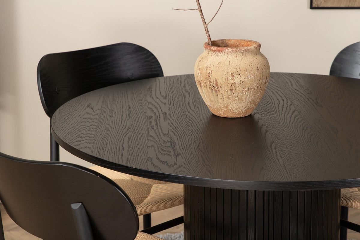 Rundes Esszimmerset Bianca mit Stuhl Polly: Tisch aus MDF und Furnier in Walnuss, vier schwarze Stühle mit Metallbeinen und Seilsitzen.