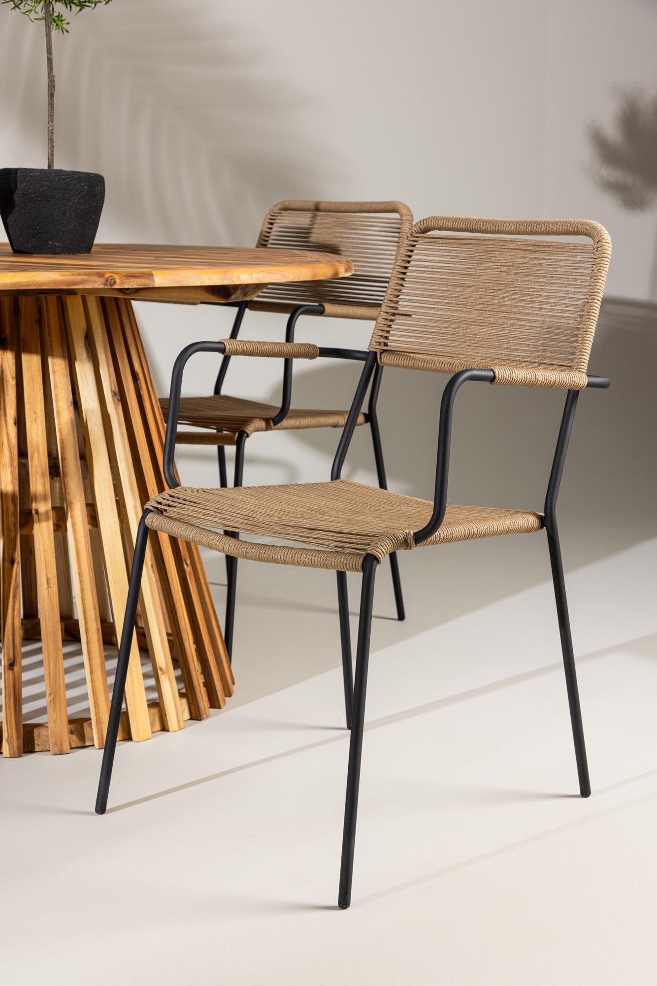 Elegantes Gartenset mit rundem Tisch und bequemen Armstühlen, ideal für stilvolle Momente im Garten oder auf der Terrasse.