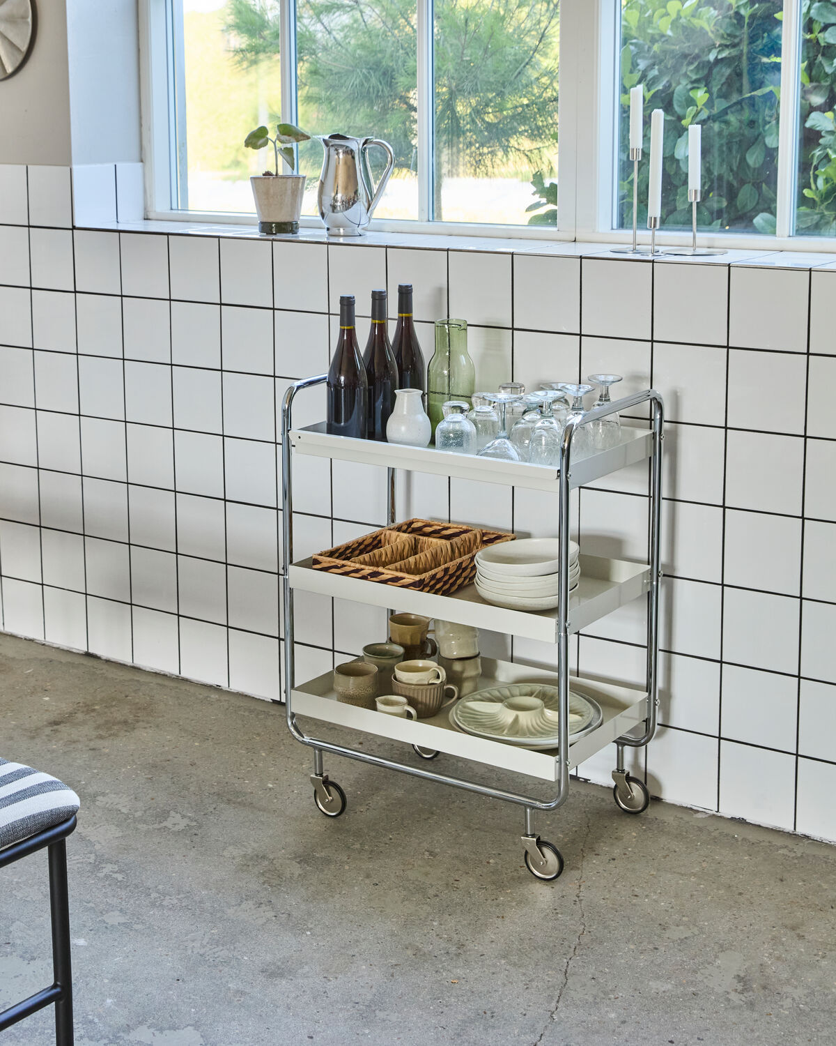 Eleganter Servierwagen in Off-White mit Chromakzenten, ideal für stilvolle Präsentationen und vielseitige Nutzung im Wohnbereich.