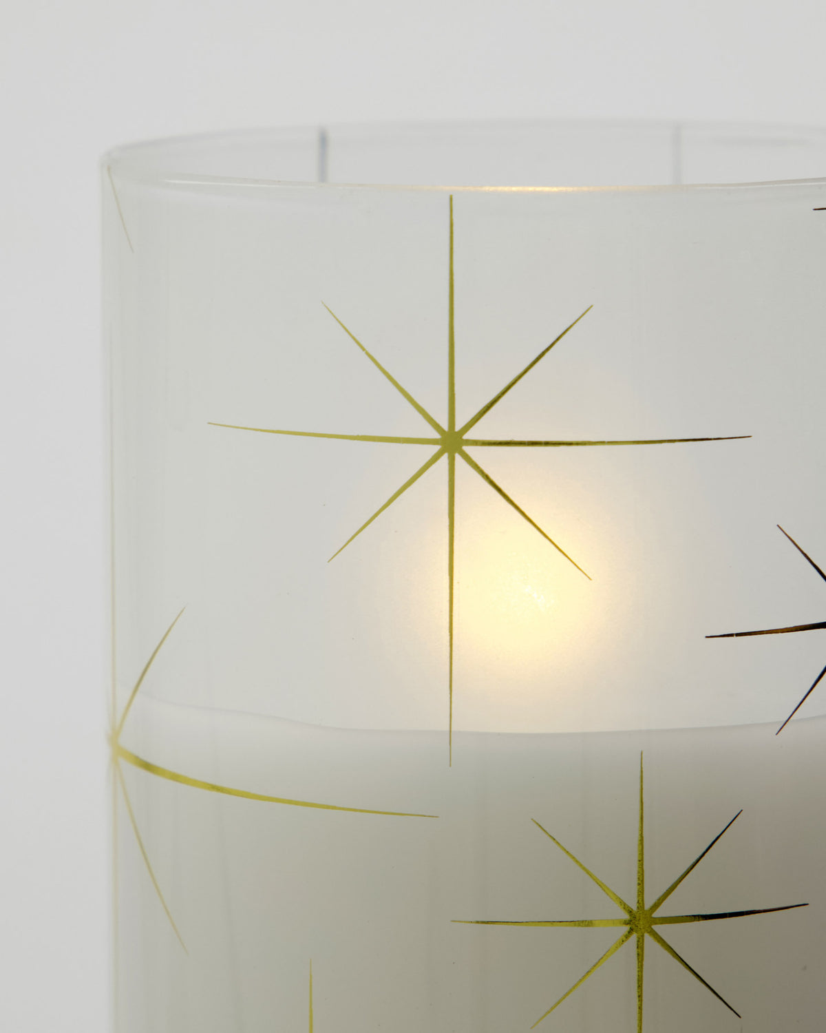 Drei weisse LED-Kerzen aus Glas und Paraffinwachs in Zylinderform mit Sternmotiv