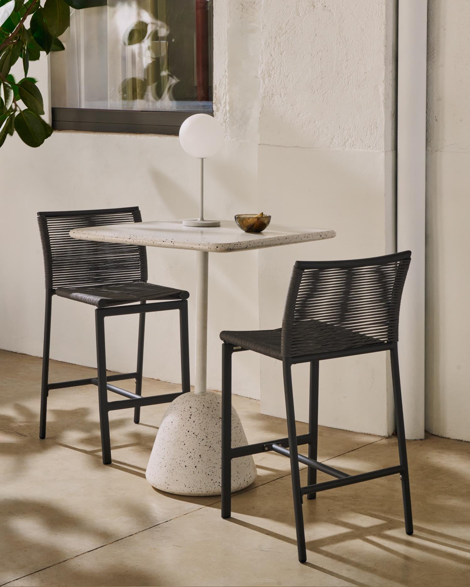 Moderner Bartisch aus weissem Terrazzo und massivem Holz, perfekt für gesellige Stunden im Freien. Langlebig und pflegeleicht.