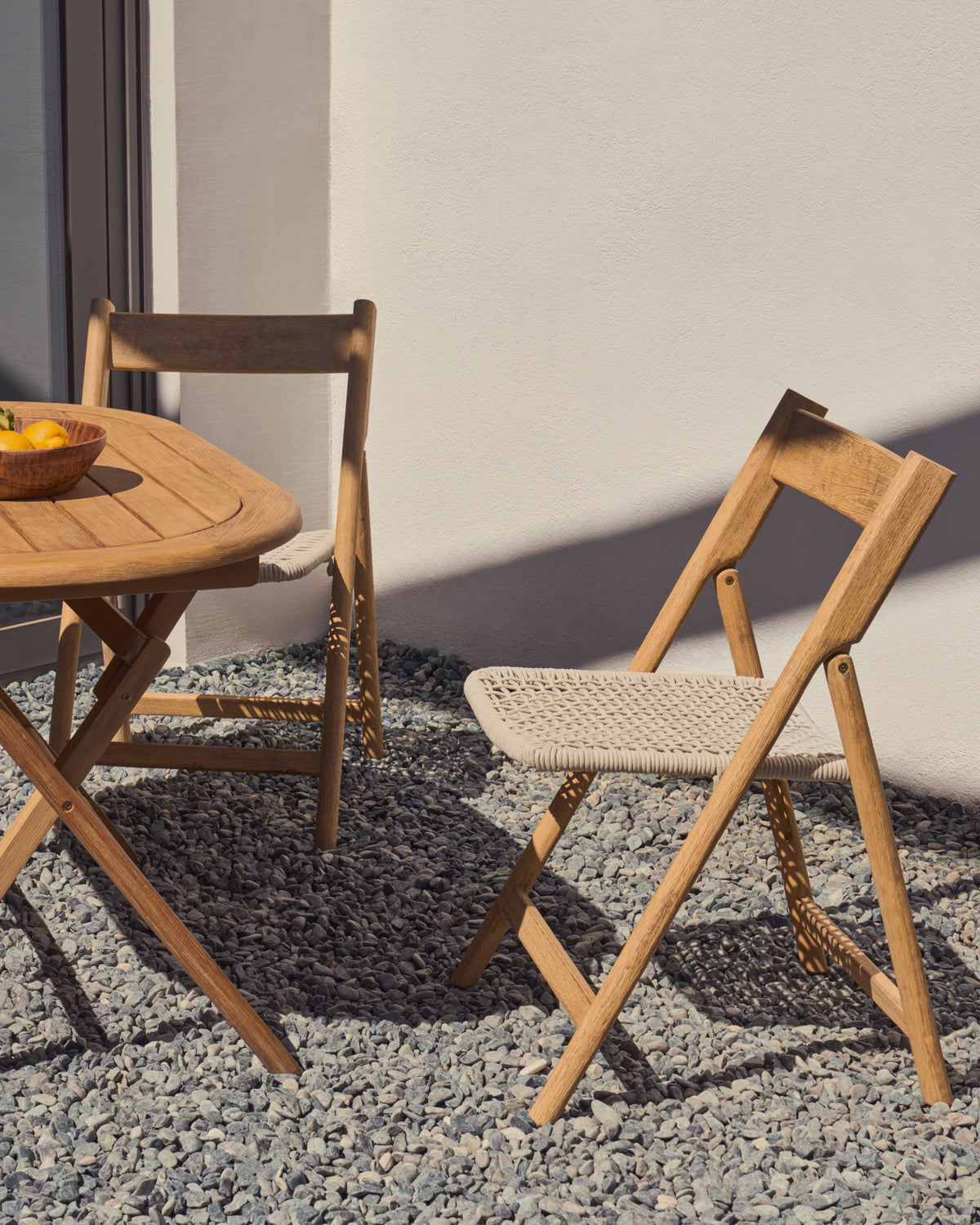 Klappstuhl Dandara aus Akazienmassivholz und einer Stahlstruktur mit geflochtener Sitzfläche in Weiss FSC 100% in Natur, Ecru präsentiert im Onlineshop von KAQTU Design AG. Gartenstuhl ist von Kave Home