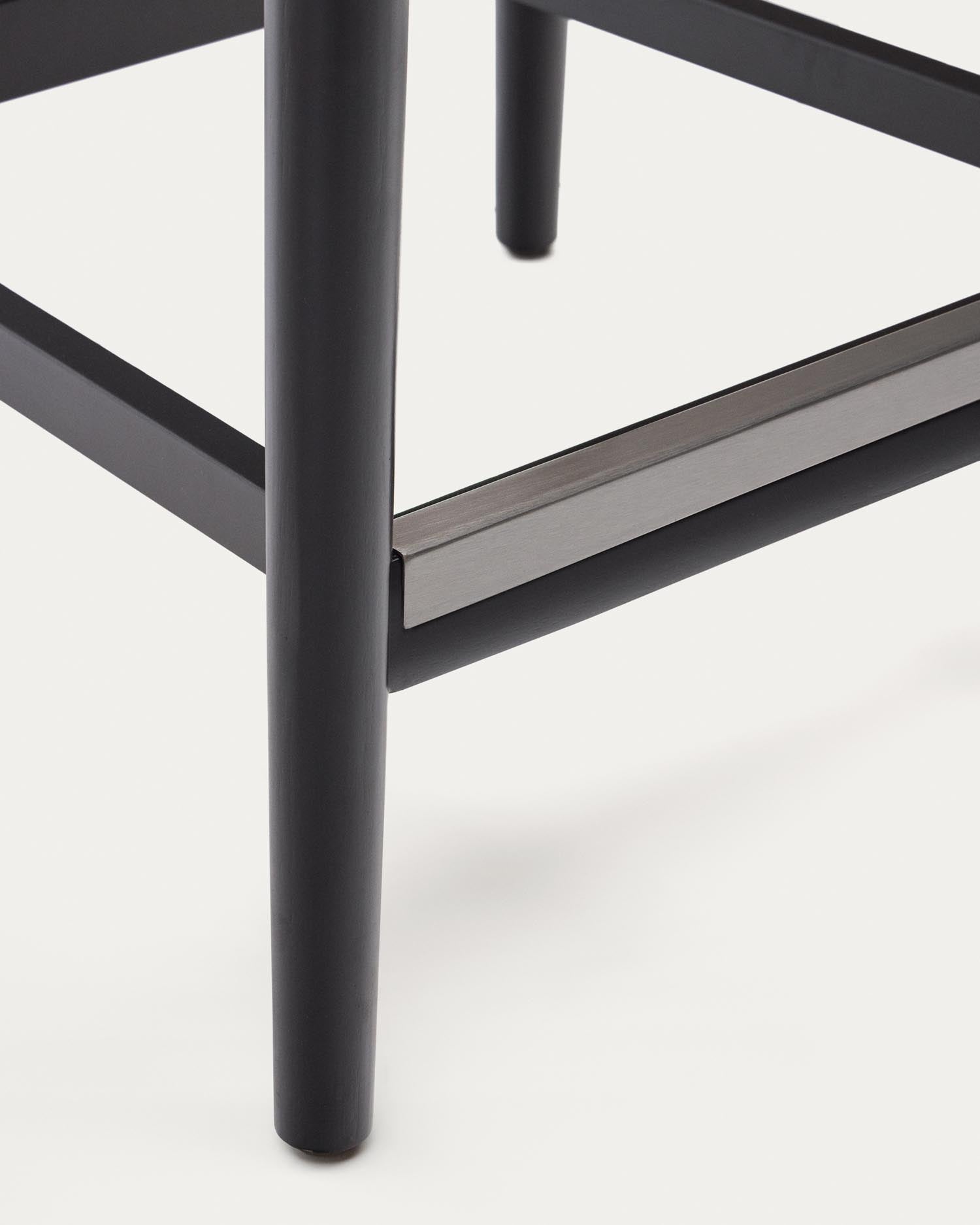 Entdecken Sie den Nina Hocker von Kave Home: Massives Akazienholz, elegantes schwarzes Finish und komfortables, handgeflochtenes Seil in Beige – ideal für Ihren Außenbereich.