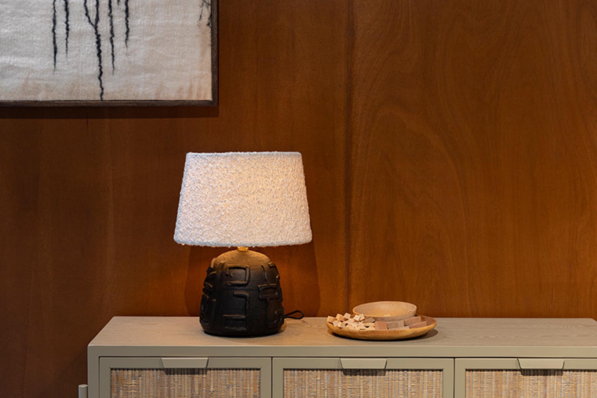 Die Renzo Tischleuchte von Dutchbone vereint stilvolles Design mit Funktionalität. Ihr Bouclé-Stoffschirm und der schwarze Terrakotta-Körper schaffen eine gemütliche Atmosphäre.