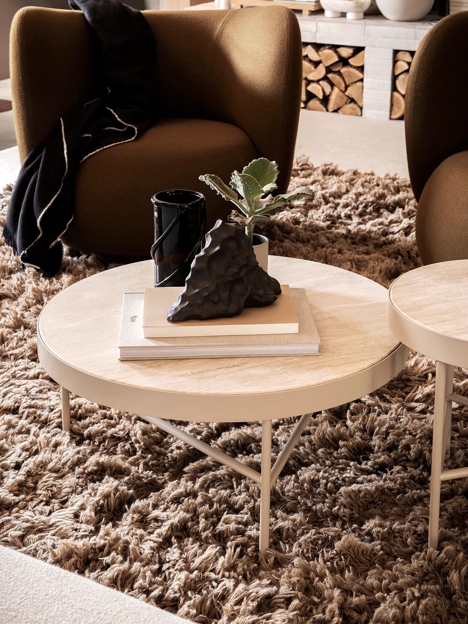 Eleganter Travertine Beistelltisch in sanften Beigetönen, ideal für stilvolle Wohnräume, präsentiert von Ferm Living.