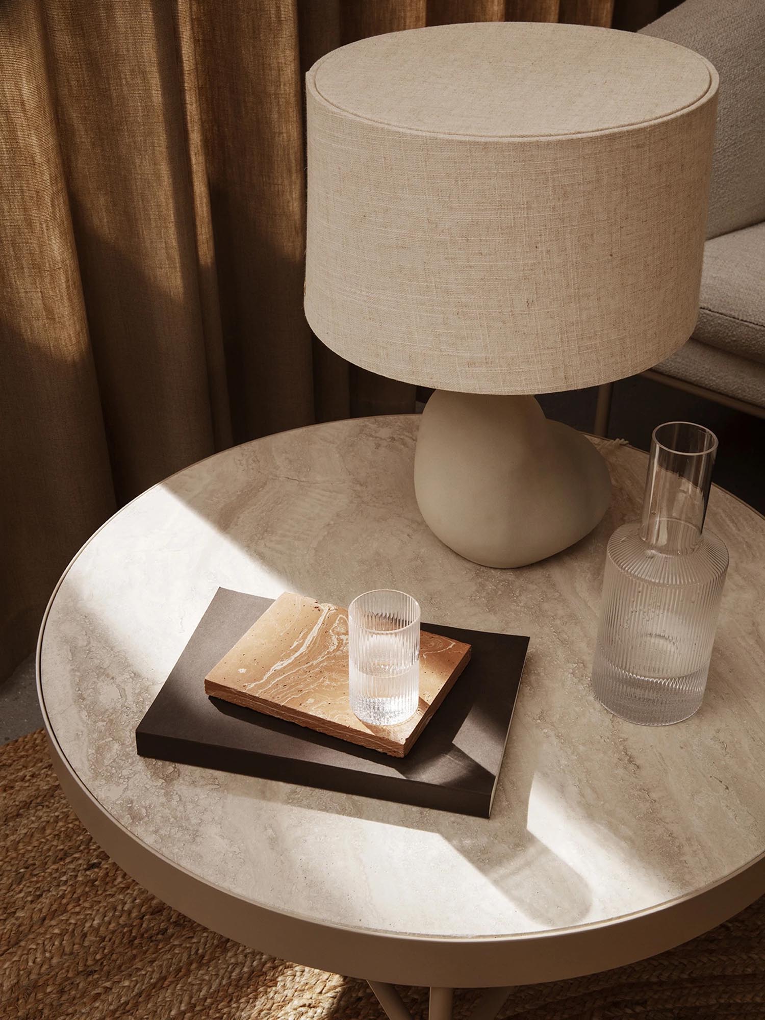 Moderner Travertine Beistelltisch in warmen Beigetönen, perfekt für einladende Wohnambiente, designt von Ferm Living.