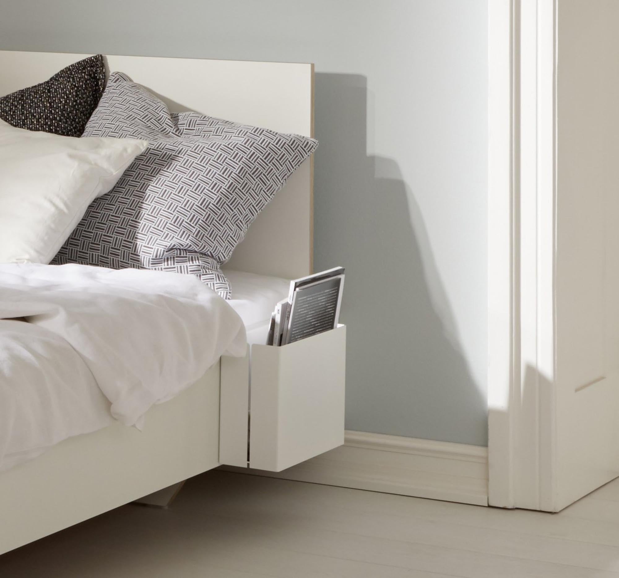 Elegante, robuste Ablage aus Stahl für FLAI Betten, pulverbeschichtet in Weiss, mit anthrazitfarbenem Wollfilz, einfach montierbar.