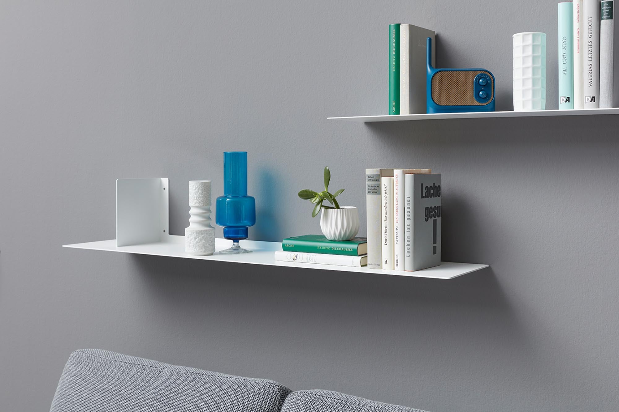 Wandregal LYN: Elegantes, schwebendes Design aus weißem Metall für stilvolle Präsentation von Büchern und Accessoires.