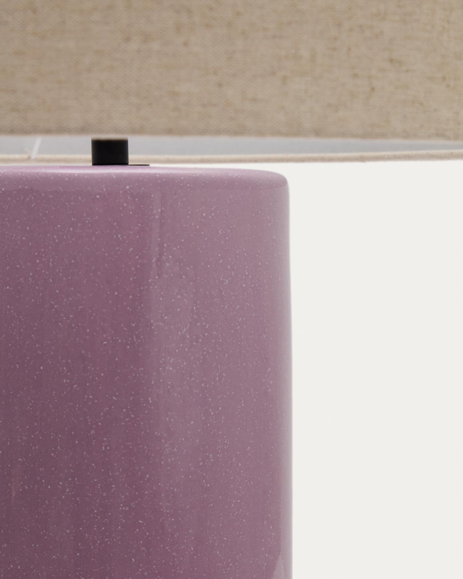 Die Tischlampe Toneric von Kave Home besticht durch ihren eleganten lila Keramiksockel und den beigen Baumwollschirm, ideal für stilvolle Akzente.