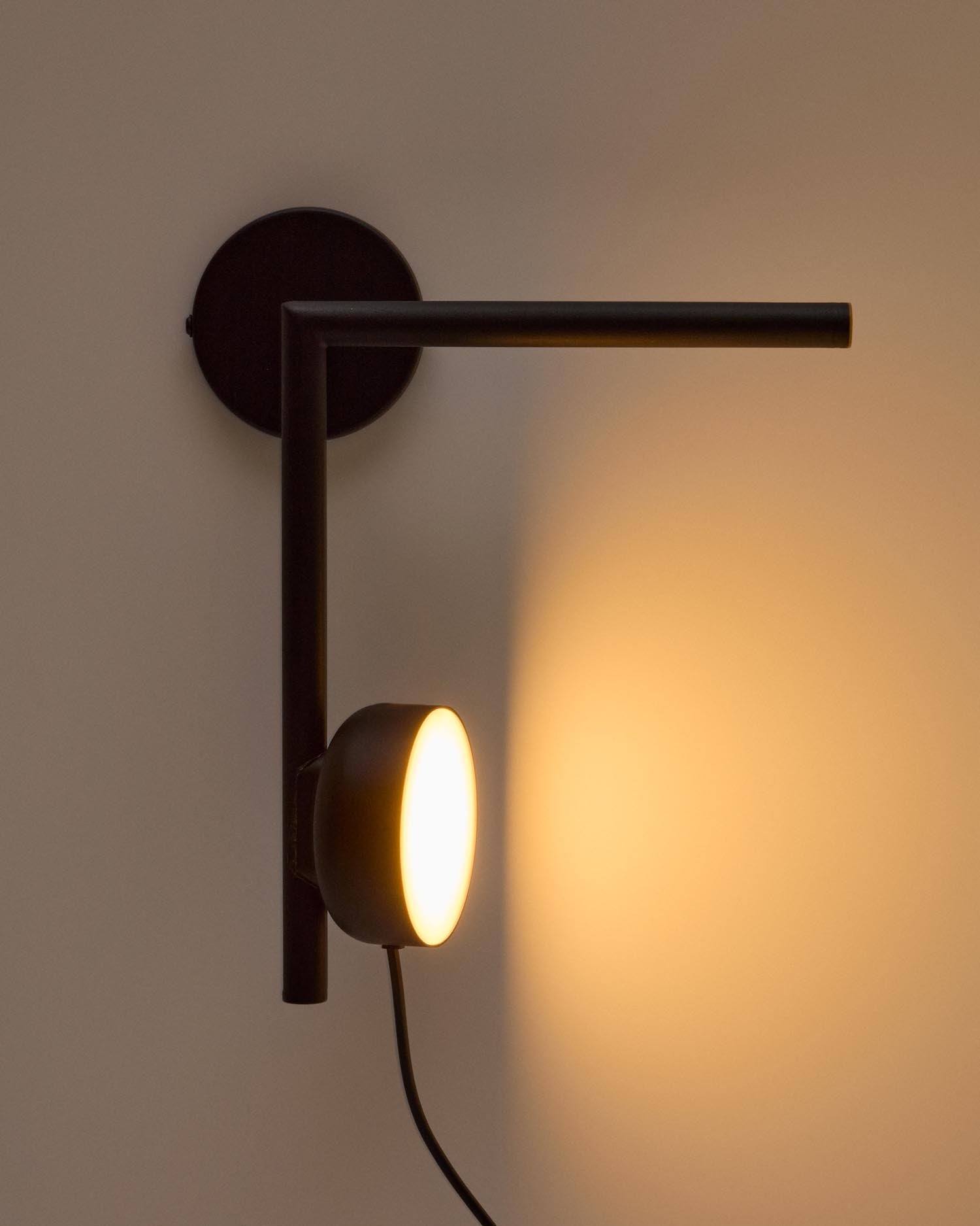 Die Wandleuchte Orey von Kave Home kombiniert elegantes schwarzes Metall mit innovativer Lichttechnik. Perfekt für individuelle Raumgestaltung.