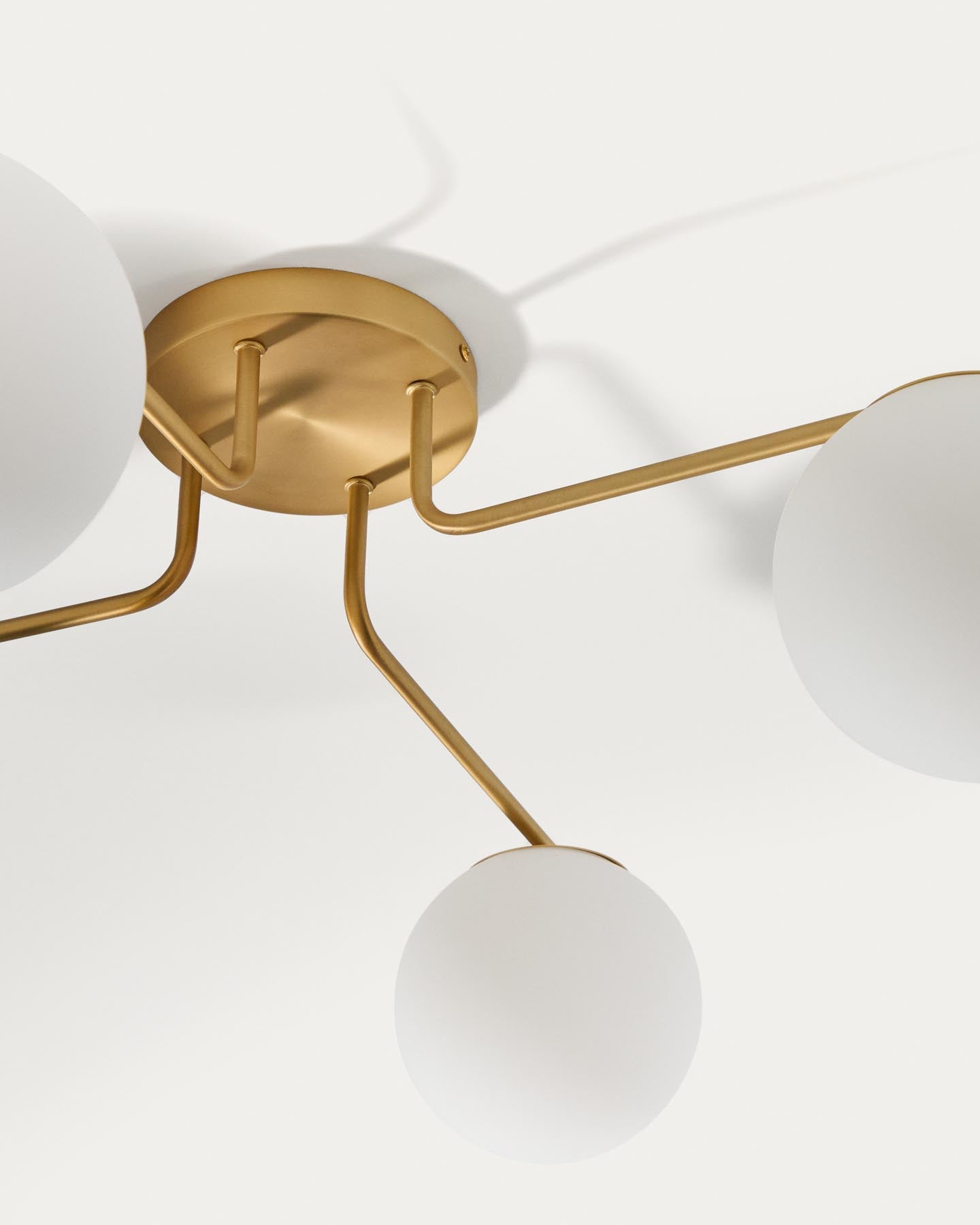 Deckenleuchte Brisia aus Metall mit gebürstetem Messing-Finish und vier mattierten Glaskugeln Ø 15 cm in Gold präsentiert im Onlineshop von KAQTU Design AG. Lampenschirm ist von Kave Home