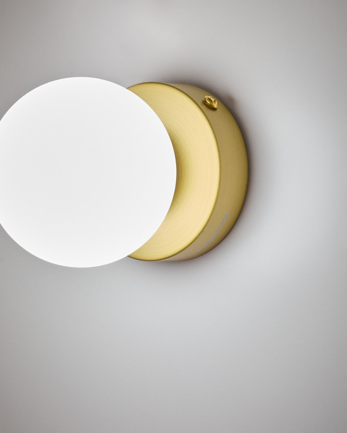 Wandleuchte Brisia aus Metall mit gebürstetem Messing-Finish und einer mattierten Glaskugel Ø 8 cm in Gold präsentiert im Onlineshop von KAQTU Design AG. Wandleuchte ist von Kave Home