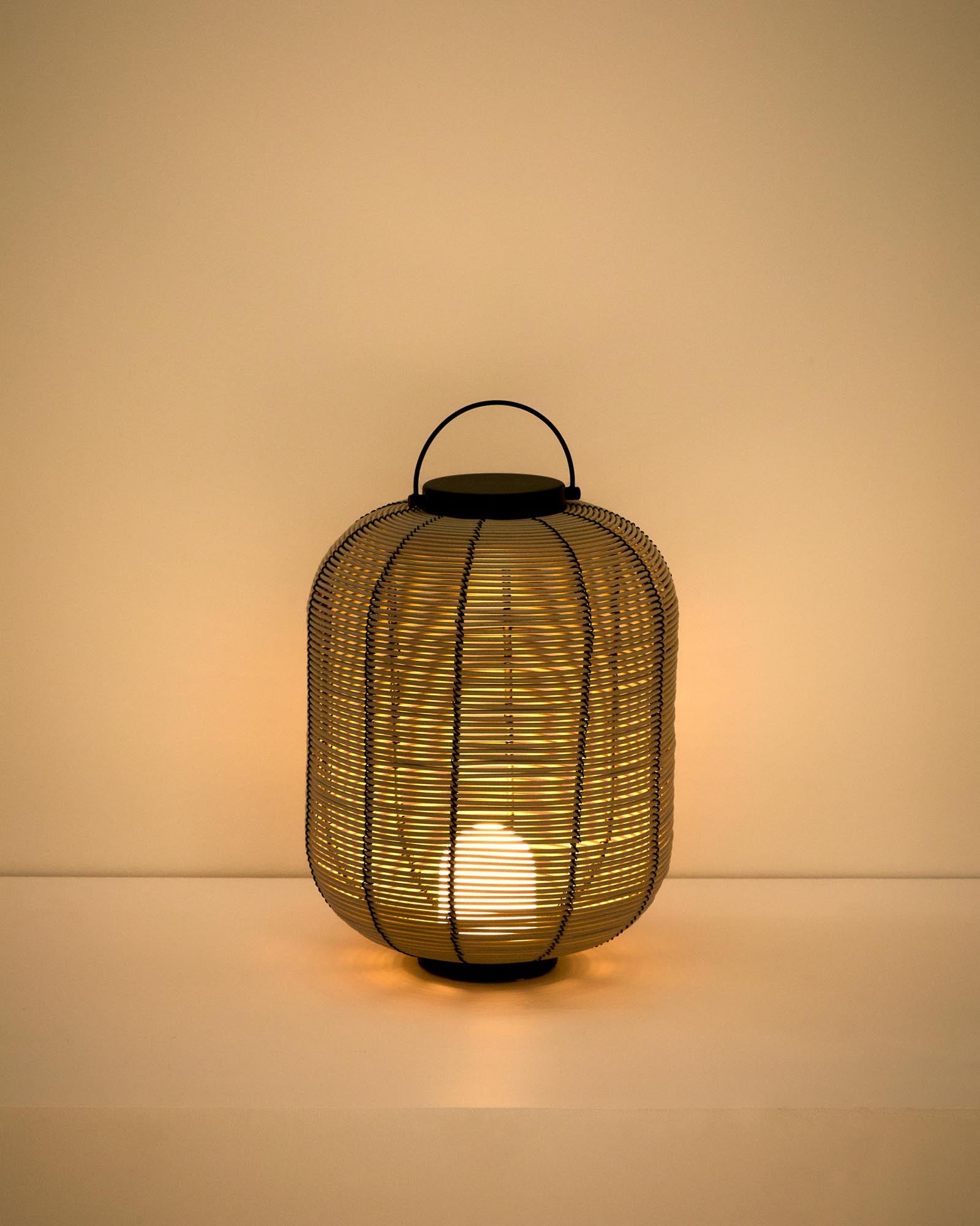 Kleine, stilvolle LED-Tischlampe Saranella aus hellgrauem synthetischen Rattan, perfekt für gemütliche Abende im Freien, von Kave Home.