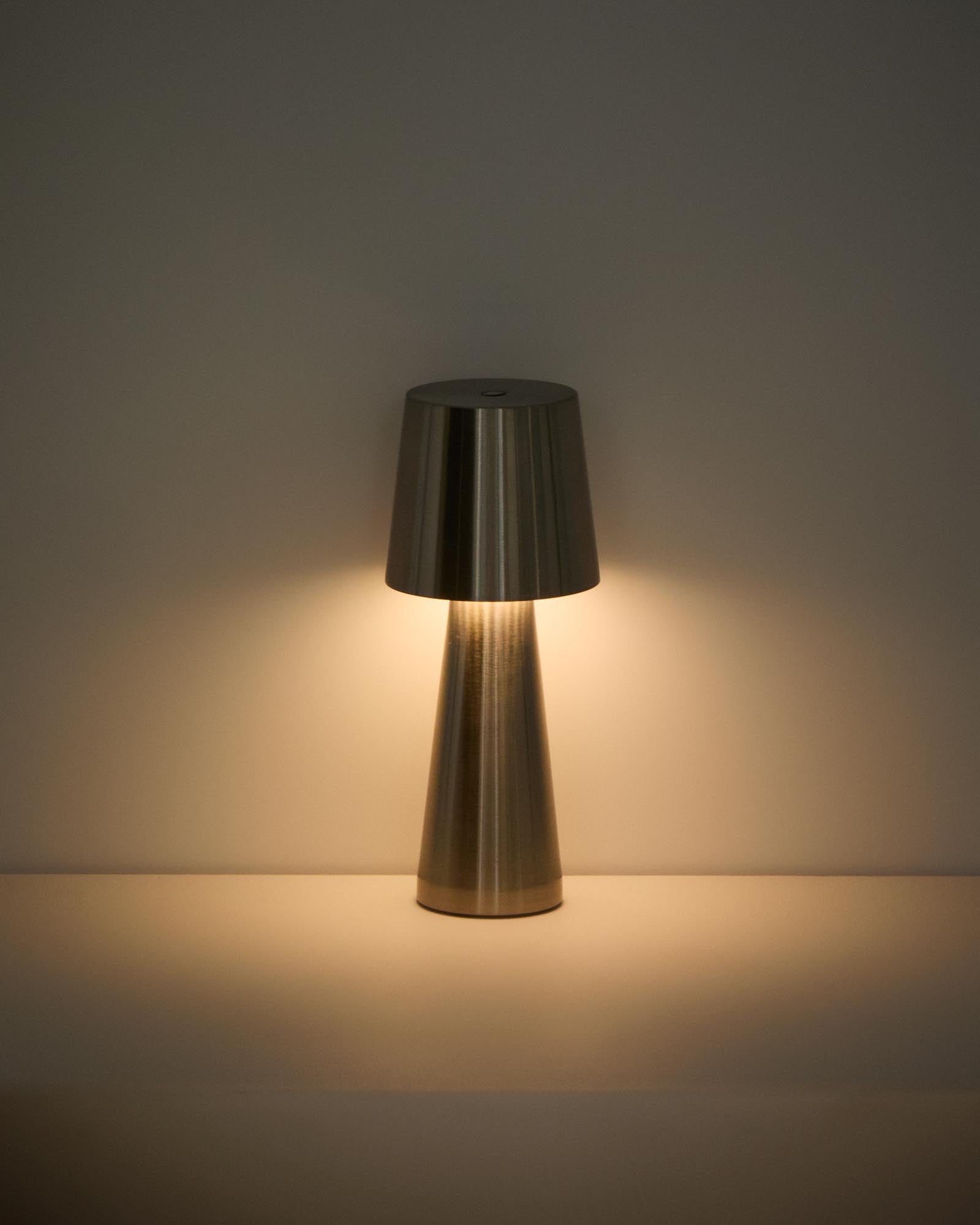 Kleine, stilvolle Tischlampe Arenys aus Metall mit schimmerndem Silberlook, perfekt für gemütliche Abende im Freien.