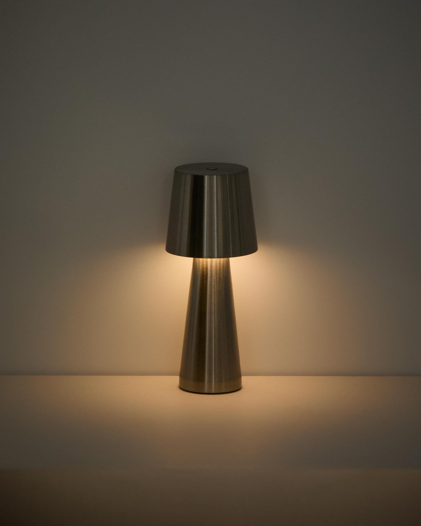 Elegante Outdoor Tischleuchte Arenys aus Metall mit glänzendem Silberfinish, ideal für stimmungsvolle Beleuchtung auf Terrassen und Balkonen.