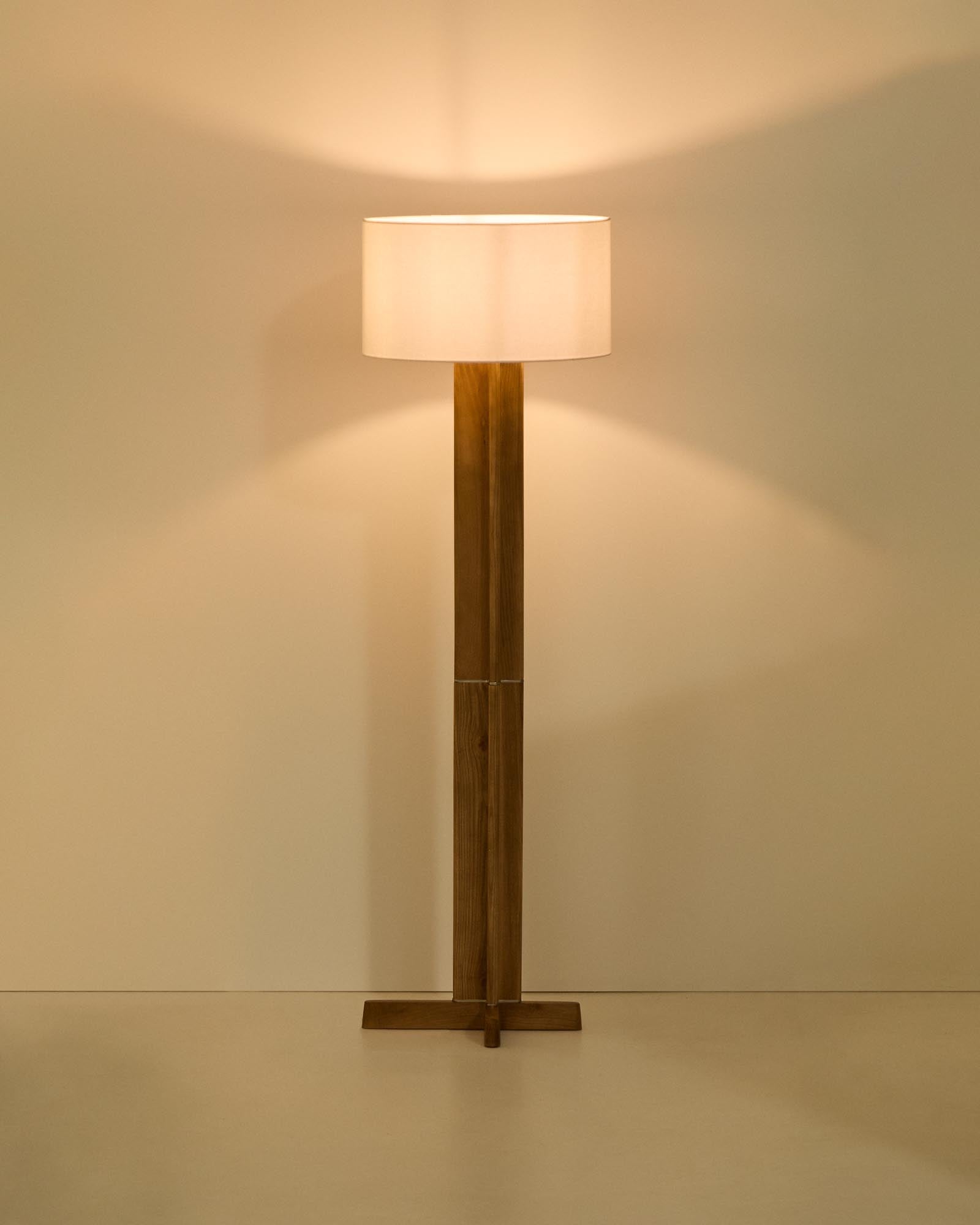 Moderne Stehlampe Niani aus Kautschukholz mit natürlichem Finish und einem eleganten elfenbeinfarbenen Baumwollschirm – perfekt für stilvolle Akzente.