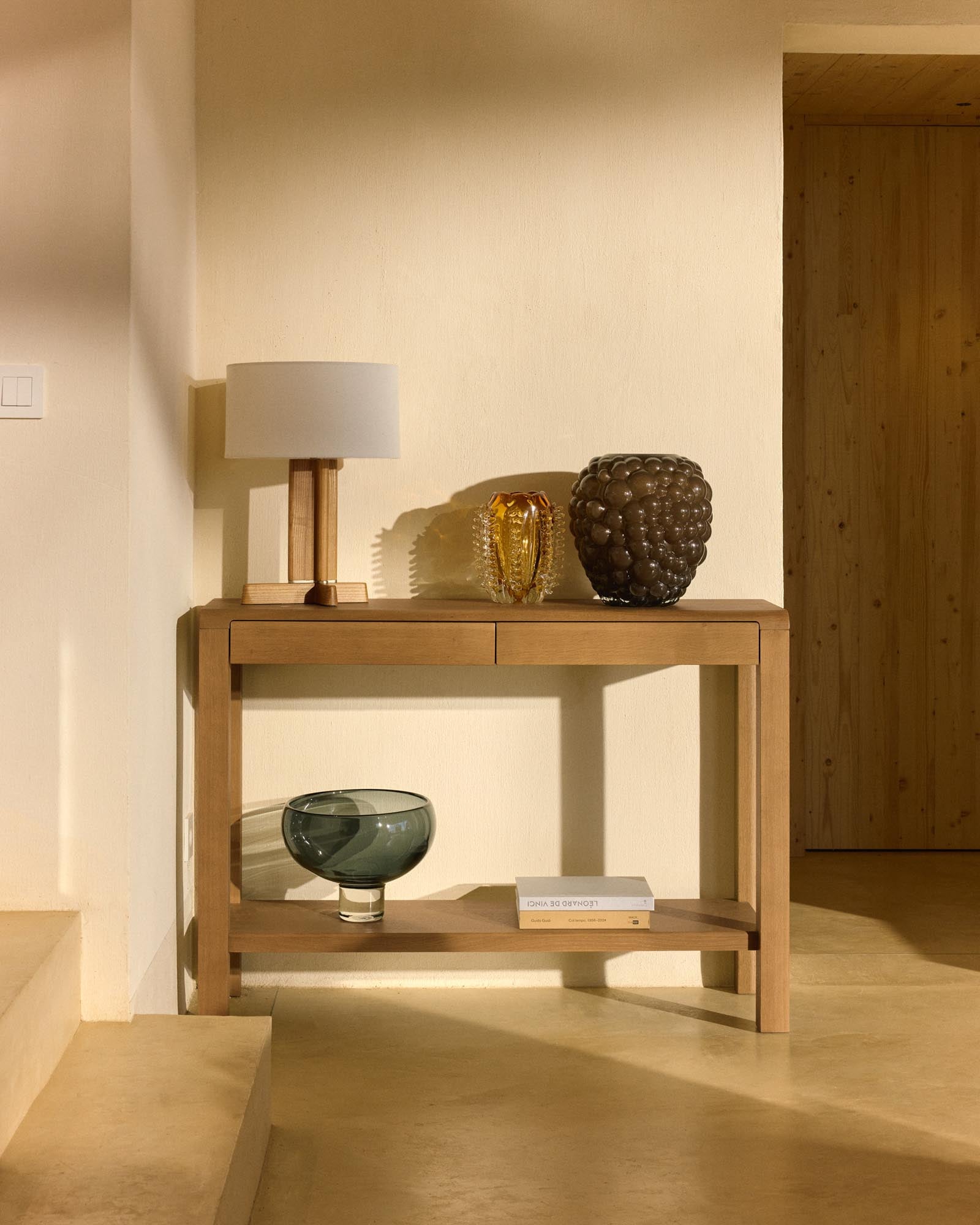 Elegante Tischleuchte Niani aus Kautschukholz mit natürlichem Finish und elfenbeinfarbenem Baumwollschirm, ideal für stilvolle Akzente.