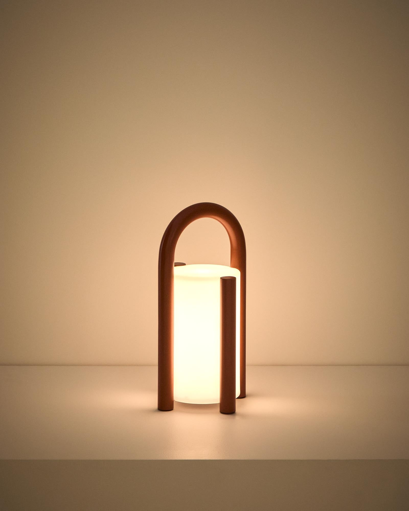 Kleine, stilvolle Tischlampe Leros aus robustem Polyethylen und terrakottafarbenem Stahl, ideal für gemütliche Outdoor-Atmosphäre.