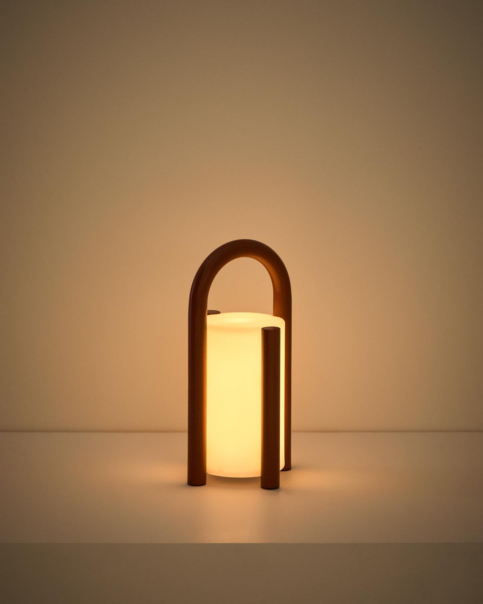 Kleine, stilvolle Tischlampe Leros aus robustem Polyethylen und terrakottafarbenem Stahl, ideal für gemütliche Outdoor-Atmosphäre.