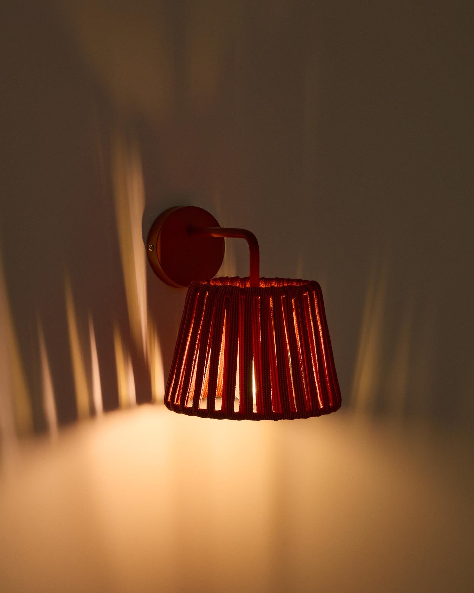Stylische Outdoor-Wandleuchte Aldet, gefertigt aus strapazierfähigem Seil und elegantem terrakottafarbenem Metall, ideal für stimmungsvolle Außenbereiche.