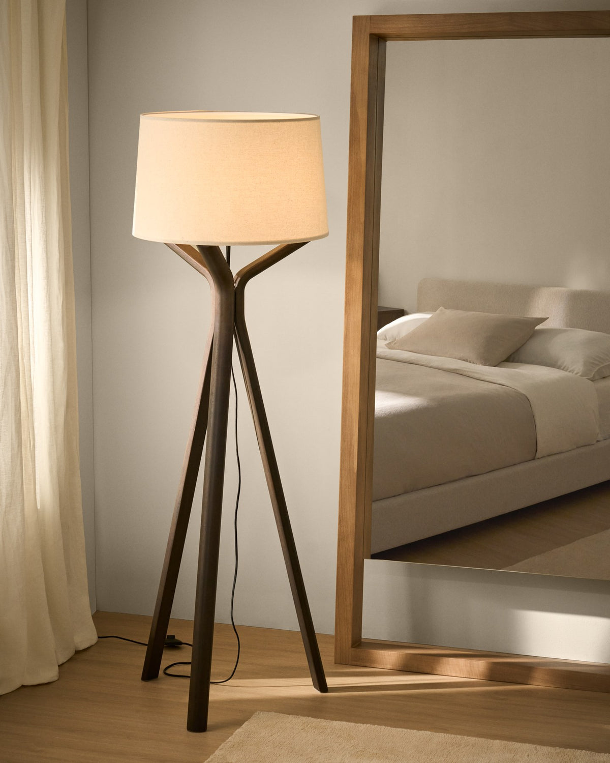 Stehlampe Ubira aus Eschenholz mit dunklem Finish, stativförmiger Basis und Lampenschirm aus Leinen in Braun.