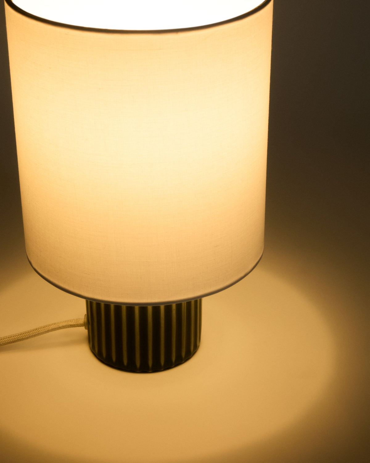 Tischlampe Eshe aus Keramik mit grün-weissem Finish und weissem Stoffschirm, runder Sockel, kompakte Form für Beistelltische oder Sideboards.