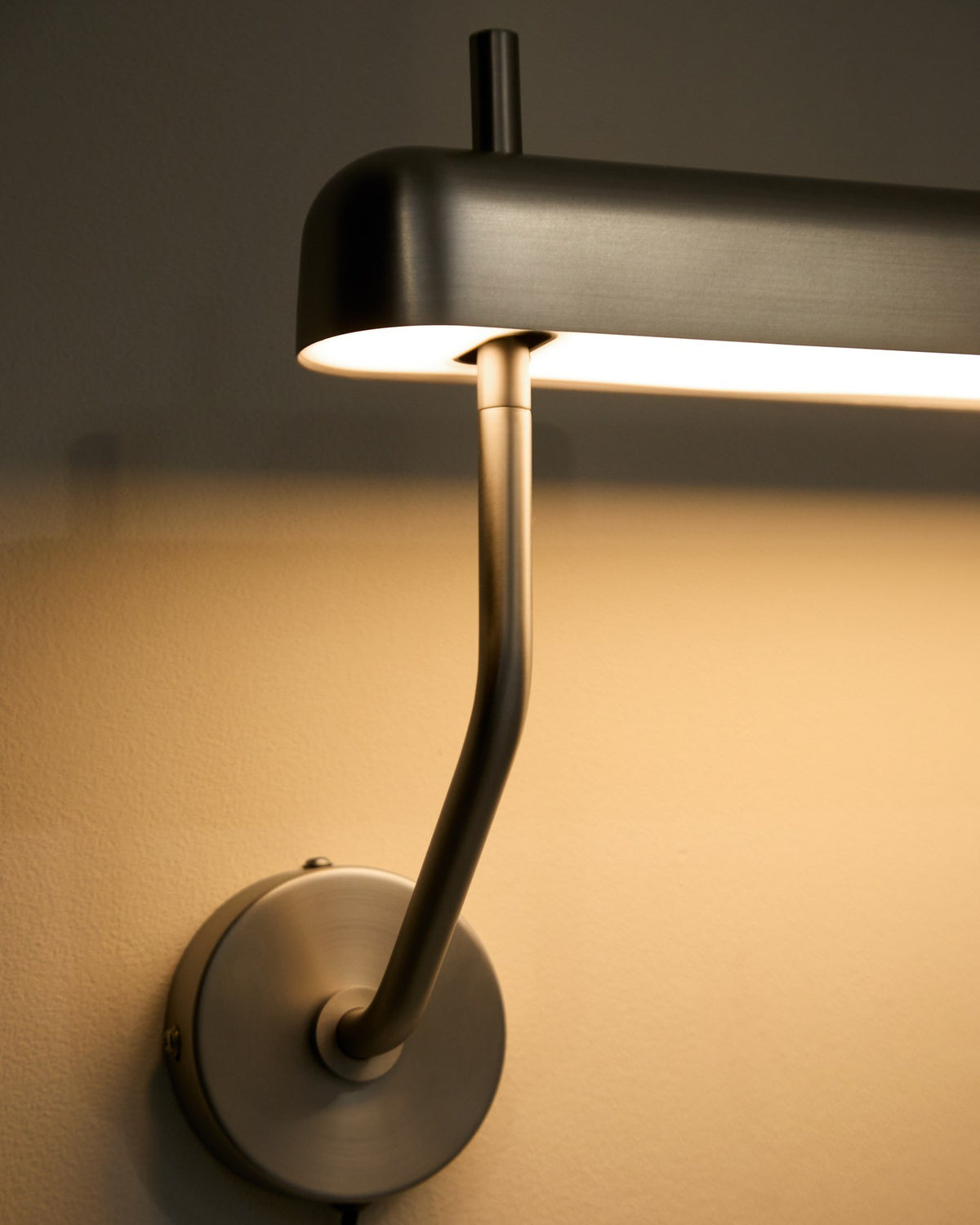 Wandleuchte Nelaia in Grau von Kave Home, Gehäuse aus Stahl und Polypropylen, schlichte Form mit seitlichem Kippschalter.