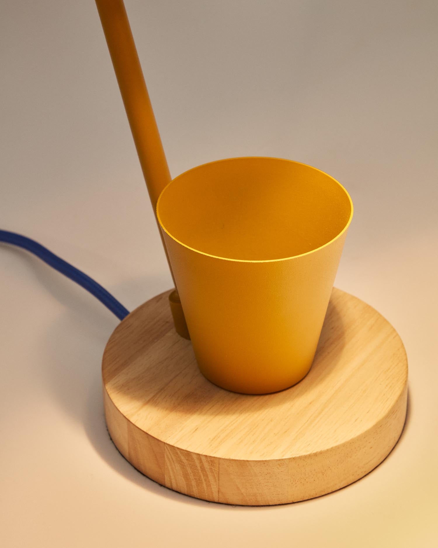 Die Katia Schreibtischlampe von Kave Home vereint stilvolles Design aus Holz und senffarbenem Metall und sorgt für eine einladende Atmosphäre im Kinderzimmer.