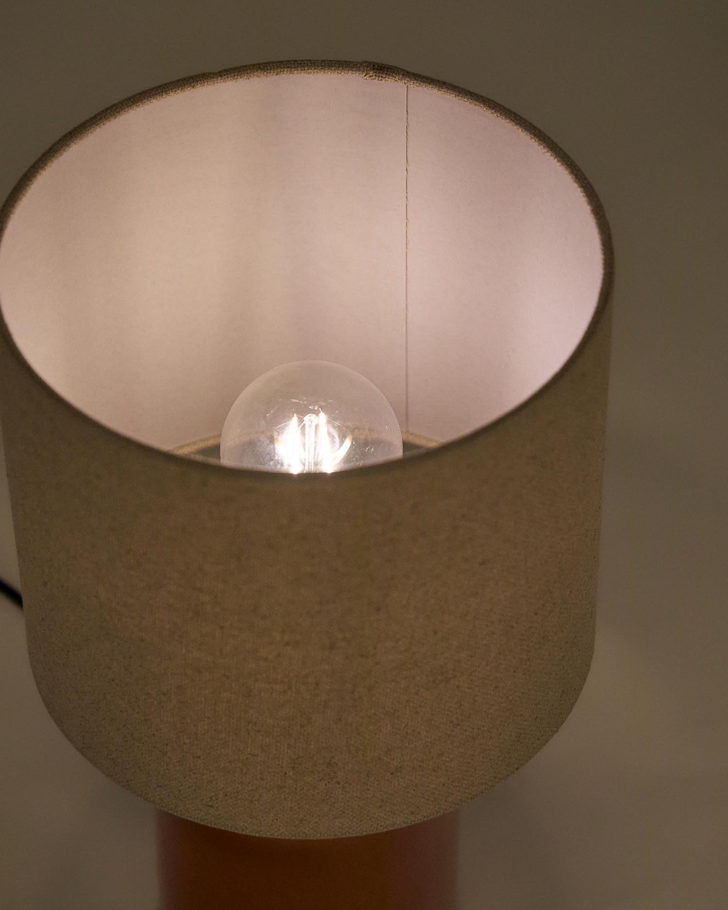 Verleihen Sie Ihrem Raum mit der Tischlampe Daeli von Kave Home einen Hauch von Eleganz. Ihr orangenes Keramikkunstwerk und der beiger Baumwollschirm schaffen eine warme Atmosphäre.