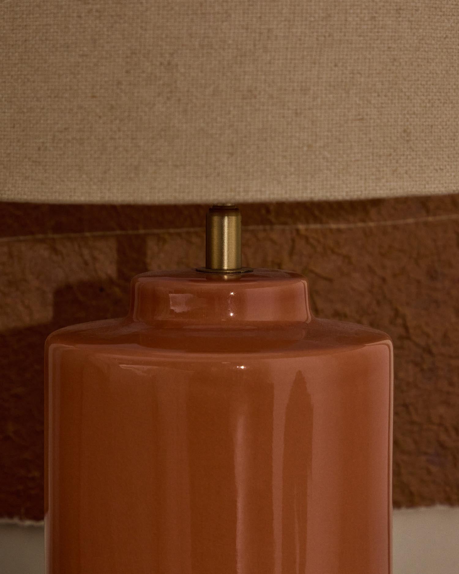 Verleihen Sie Ihrem Zuhause mit der Tischlampe Daeli von Kave Home einen Hauch von Eleganz. Ihr oranger Keramiksockel und der beiger Baumwollschirm schaffen eine warme Atmosphäre.