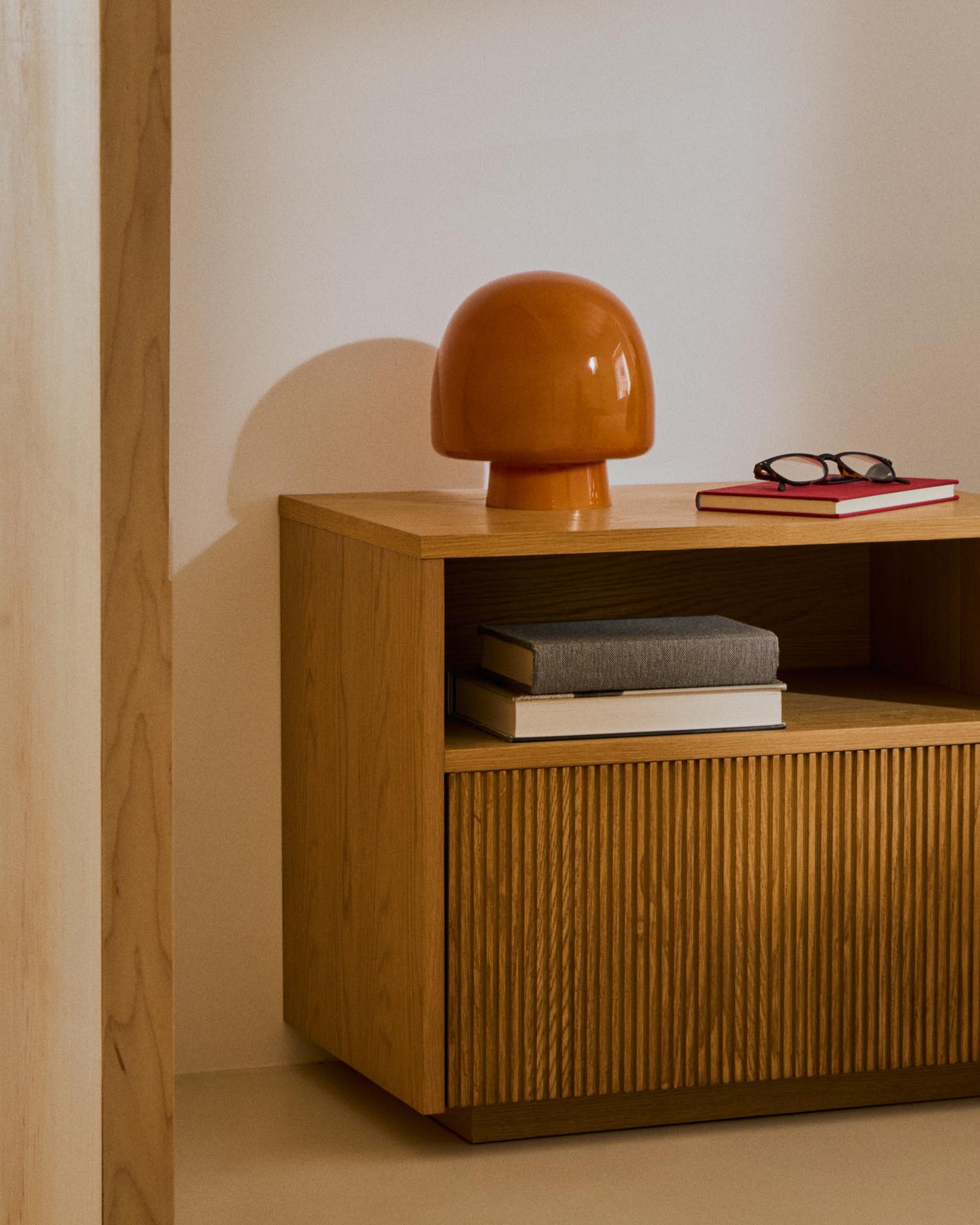 Entdecken Sie die Tischleuchte Reig von Kave Home: Ein stilvolles Kunstwerk aus orangefarbenem Glas, das warmes Licht und retro Eleganz vereint.