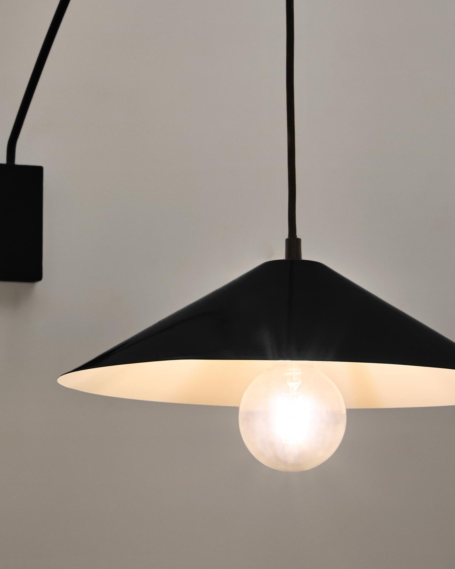 Elegante Kally Wandleuchte aus Metall mit schwarzem Finish, flexibler Arm für gezielte Beleuchtung und stilvolle Holzelemente für ein modernes Ambiente.