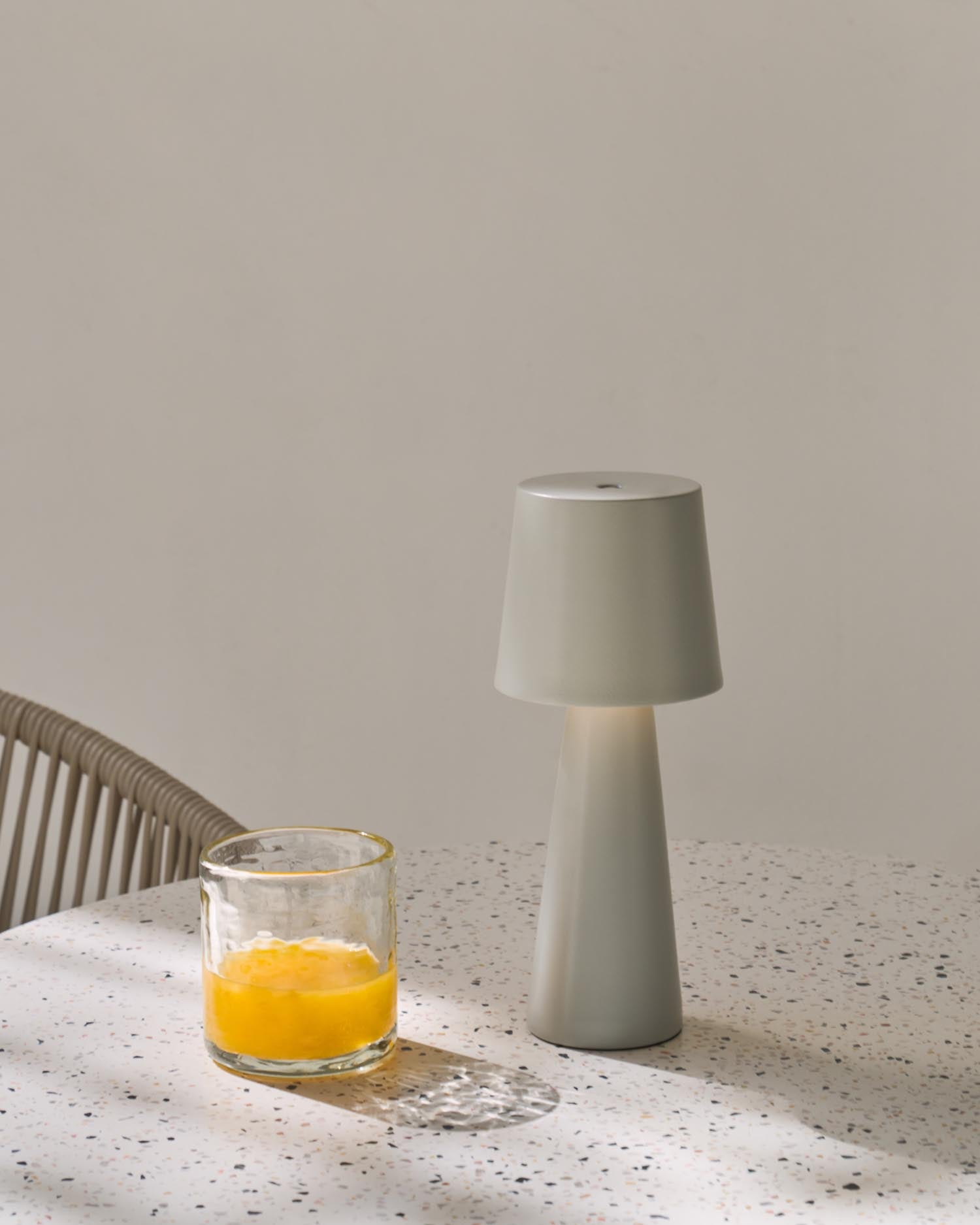 Die Arenys Outdoor Tischlampe von Kave Home kombiniert modernes Metall mit natürlichem Holz, ideal für stimmungsvolle Akzente im Freien.