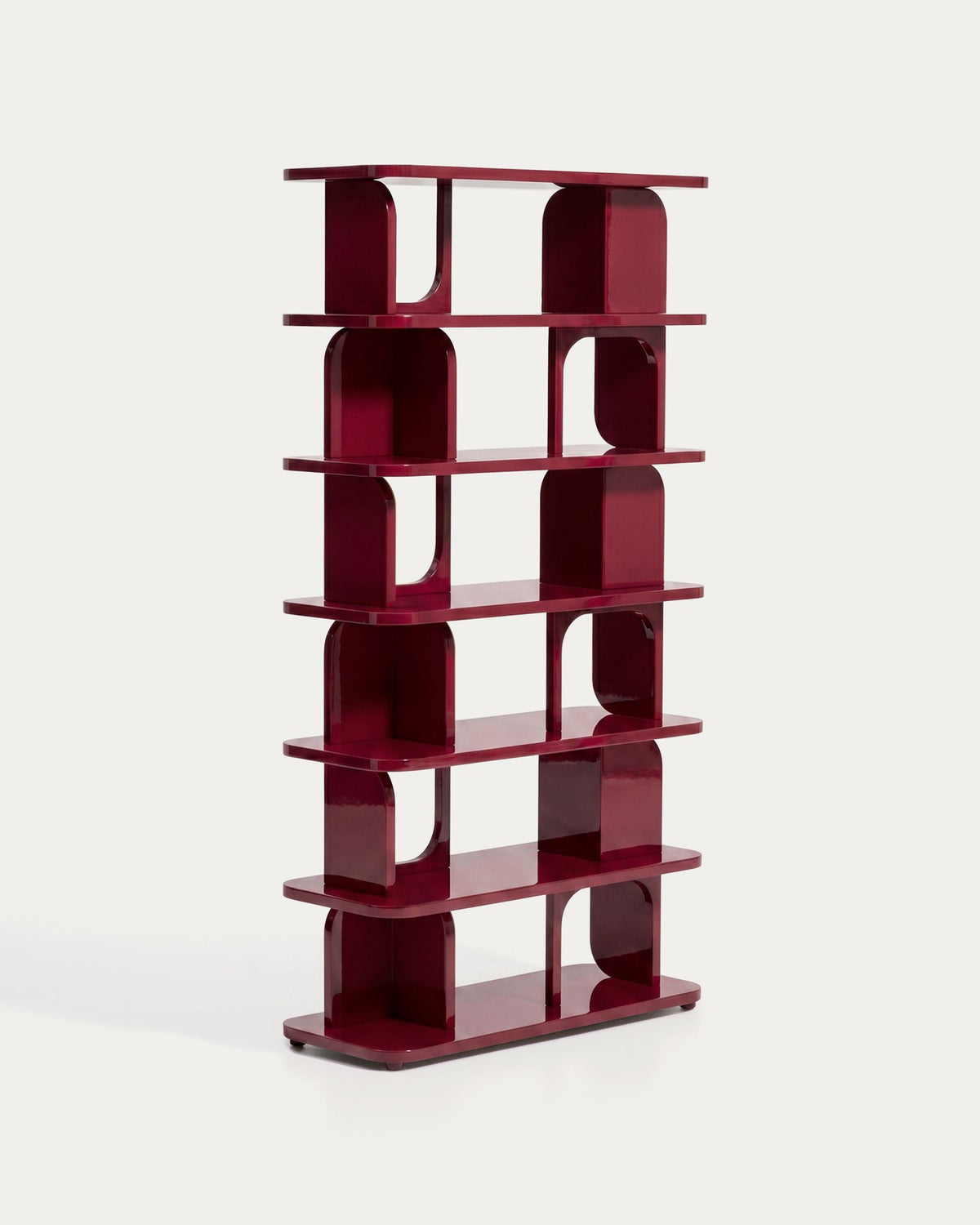 Freistehendes Regal aus MDF und Buchenholz in glänzendem Granatrot, mit geometrischen Aussparungen und mehreren übereinander liegenden Ablageflächen.